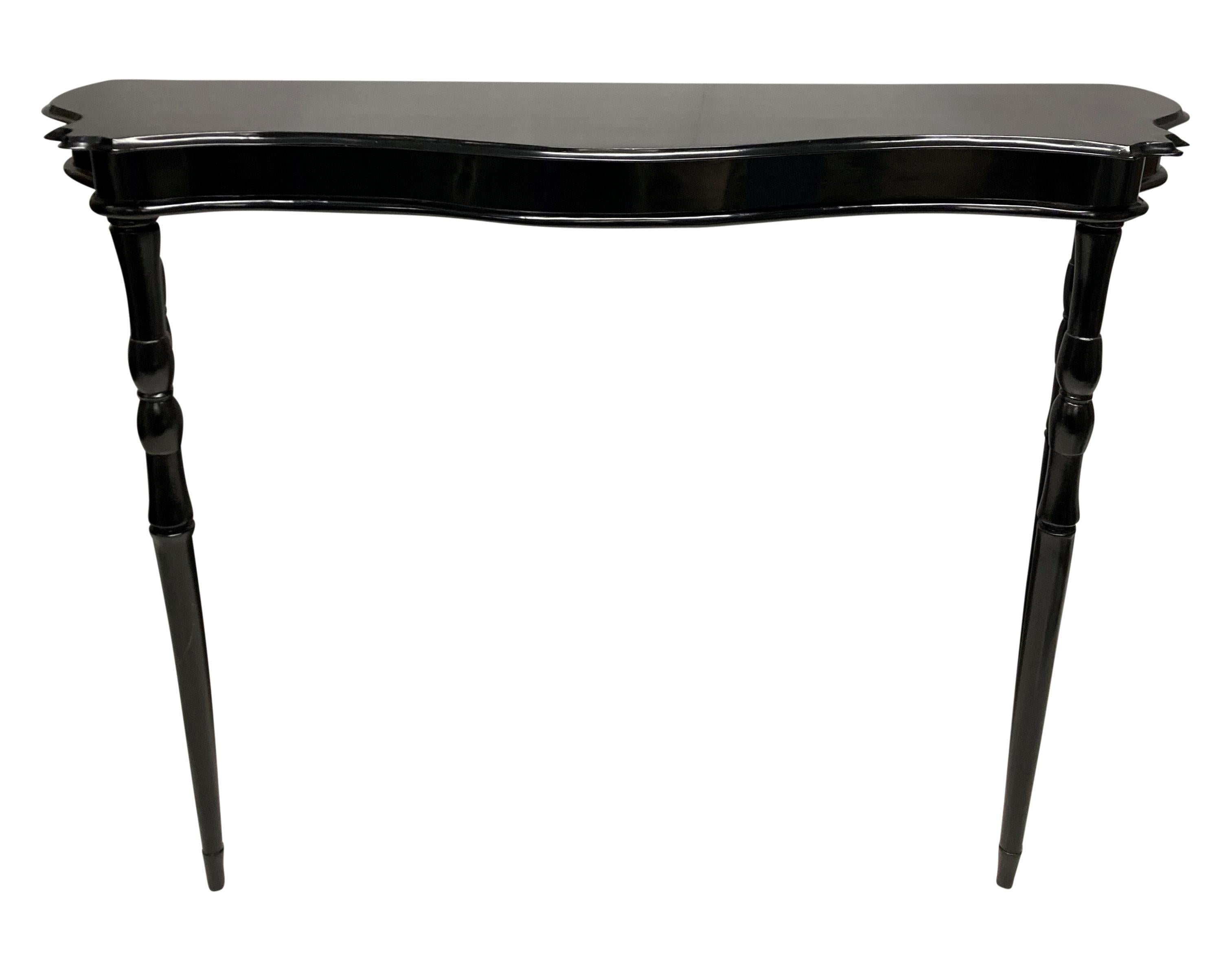 An elegant Italian black lacquered console table with serpentine front and on four tapering legs.