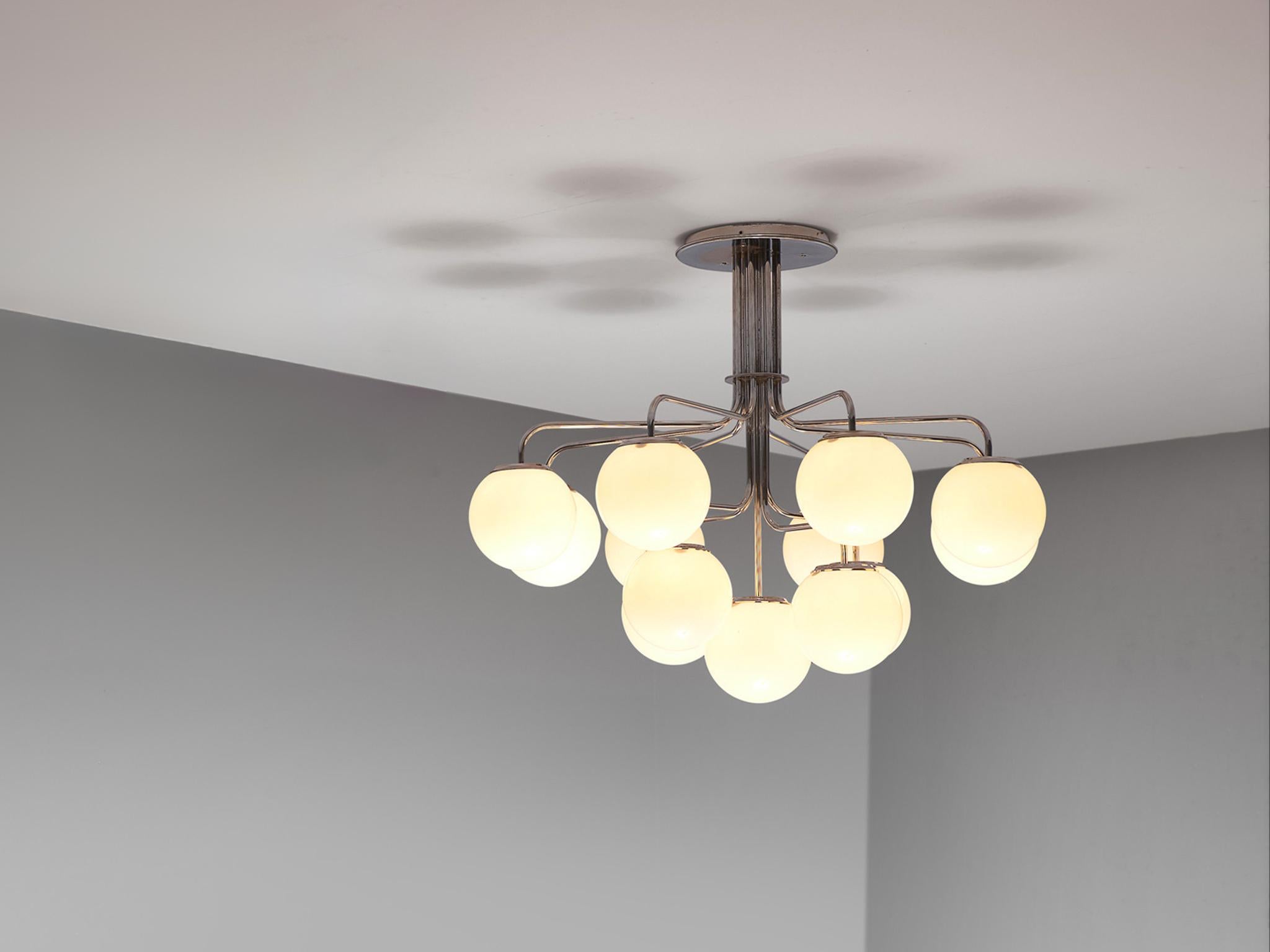 Lustre, chrome, acier, aluminium, verre, Italie, années 1970

Cet imposant lustre est doté de douze abat-jours ronds en verre opaque blanc qui diffusent une lumière chaude et douce. Le lustre est composé d'une armature en acier avec douze tubes