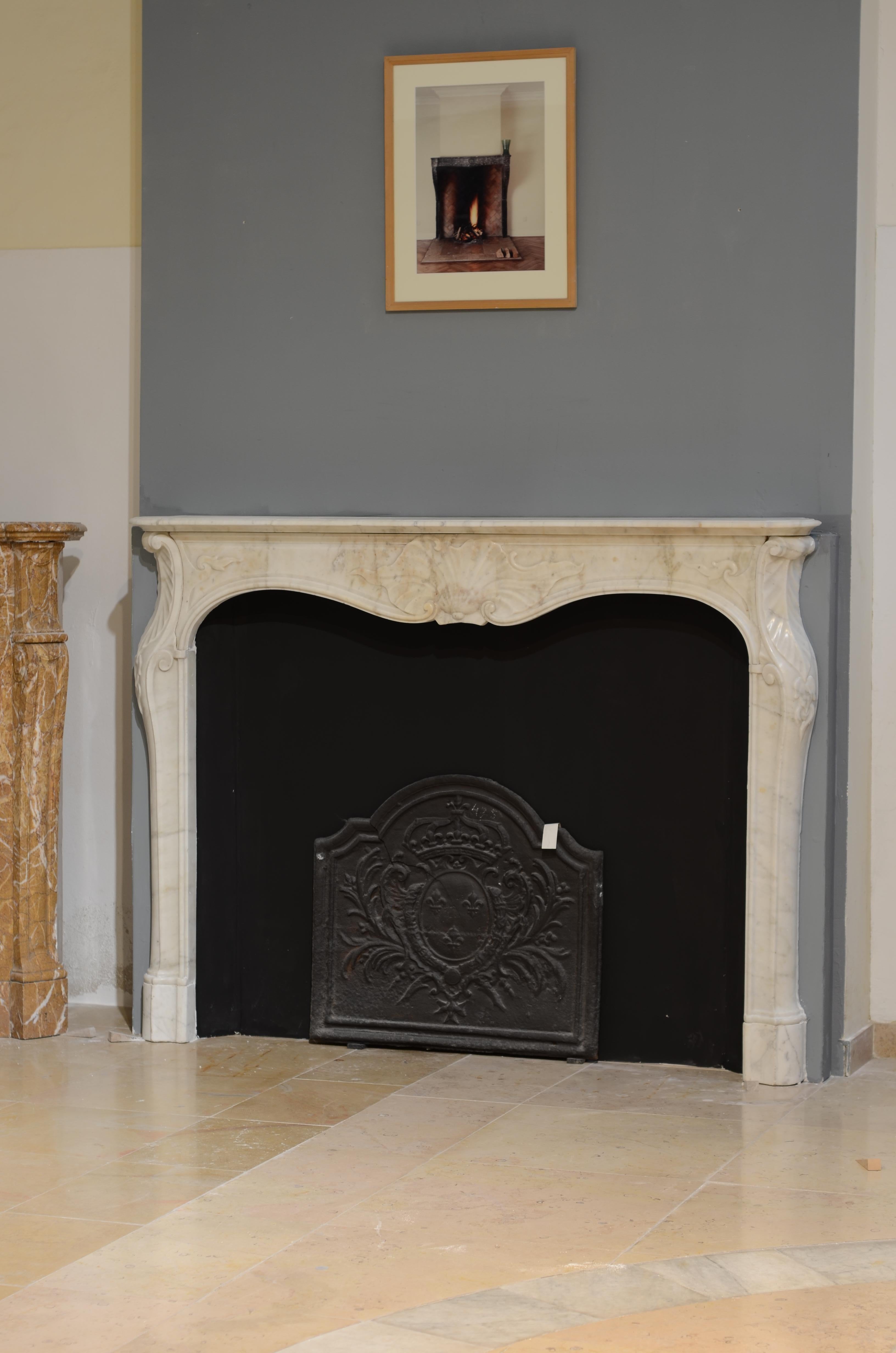 Lovely elegant 18th century fireplace mantel in Carrara white marble.
This Italian beauty with its beautifully shaped jambs with scroll to top was originally build into the wall. 
The way the frieze sits behind the scrolls of the jambs, the lovely