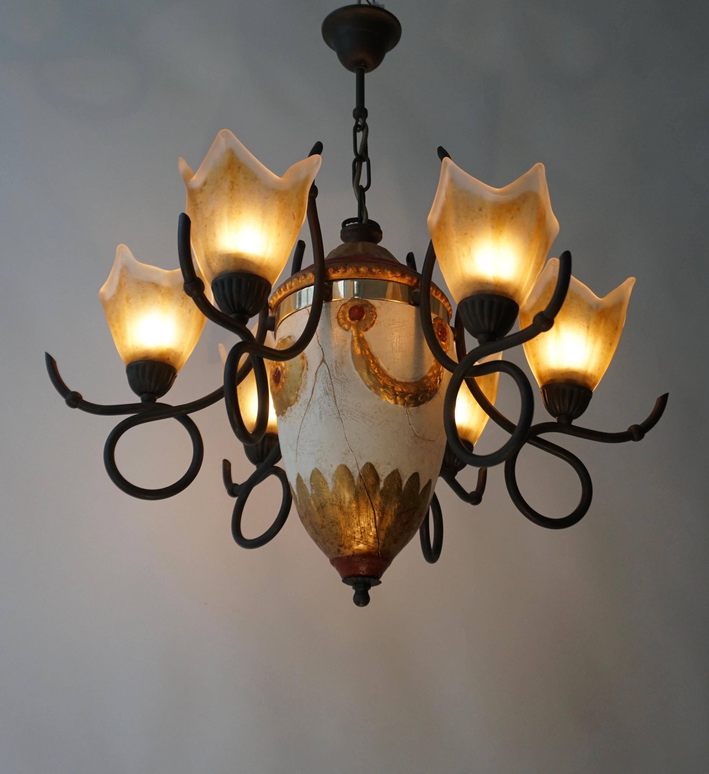 A  Hollywood Regency six-armed Italian chandelier in glass and painted wood manufactured in the mid-century (1970s). 

The chandelier has six sockets for small incandescent lamps with screw base or E14 type LEDs. It is possible to install this