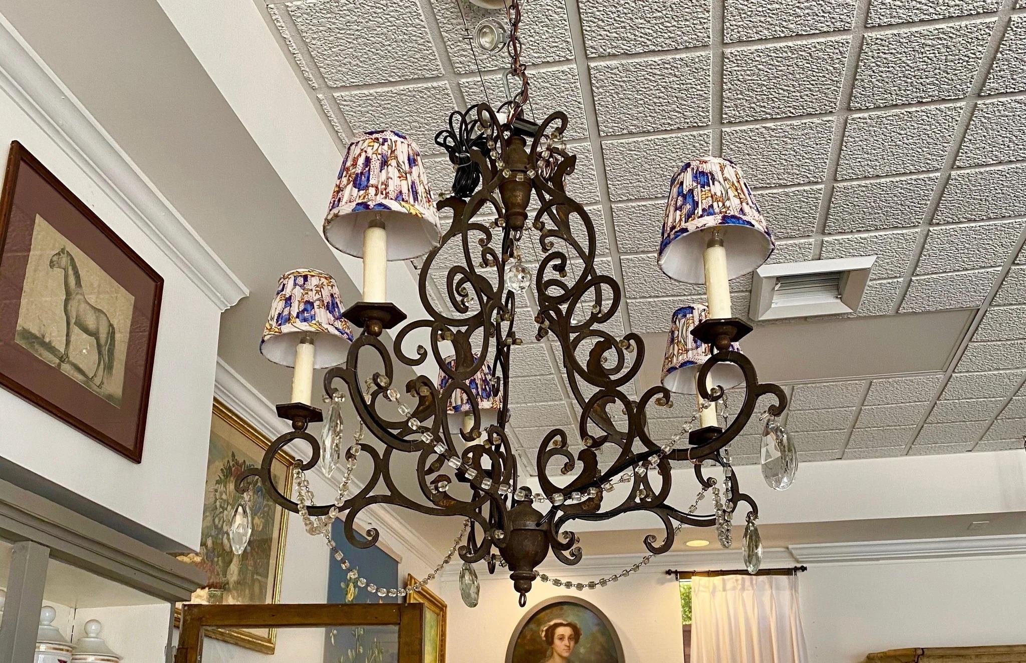 Iron and crystal chandelier, wired and in excellent condition, some gilt detail. Price included silk custom-made shades. Can deduct $250 if not taking shades.