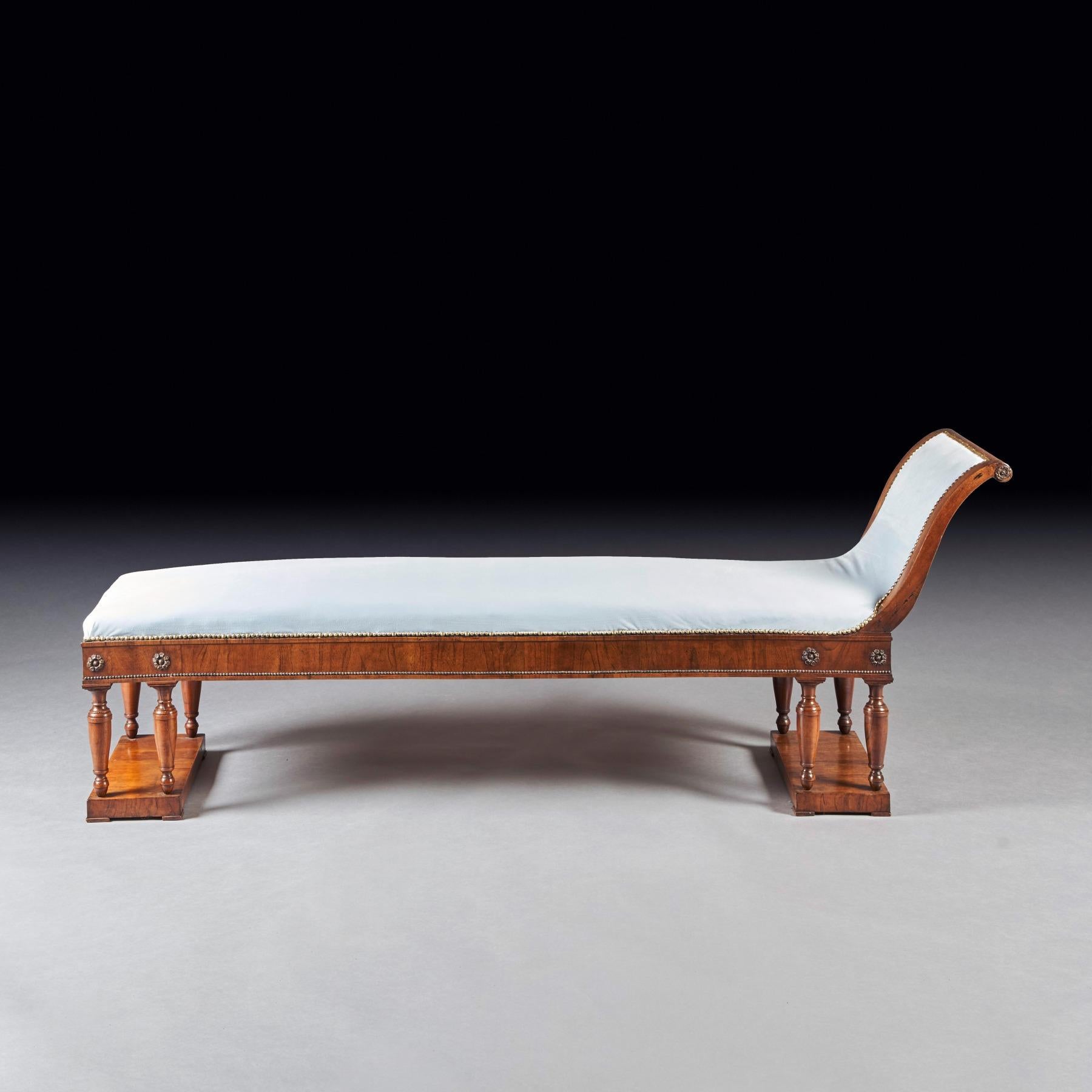 A very elegantly drawn Italian Neoclassical Empire walnut and parcel gilt scroll end bench or recamier.

Italian Circa 1810

The raised scroll end with a walnut surround covered in a light blue velvet, the frieze having parcel gilt flower head