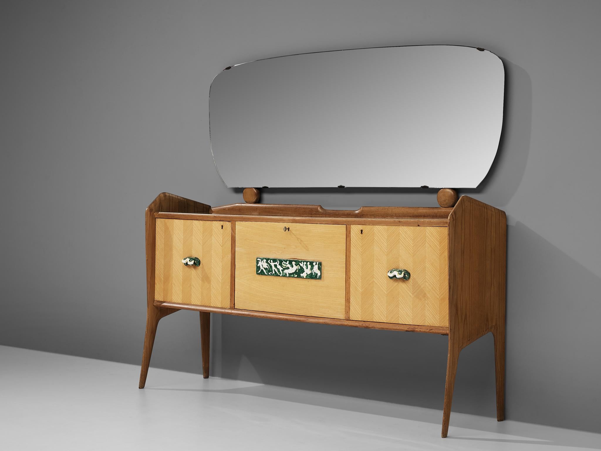 Sideboard with big mirror and dry bar, ash, ceramic, glass, Italy, 1950s

Beautiful and interestingly detailed sideboard from Italy, made in the 1950s. This three-door sideboard holds a big mirror with rounded edges. The sideboard features three