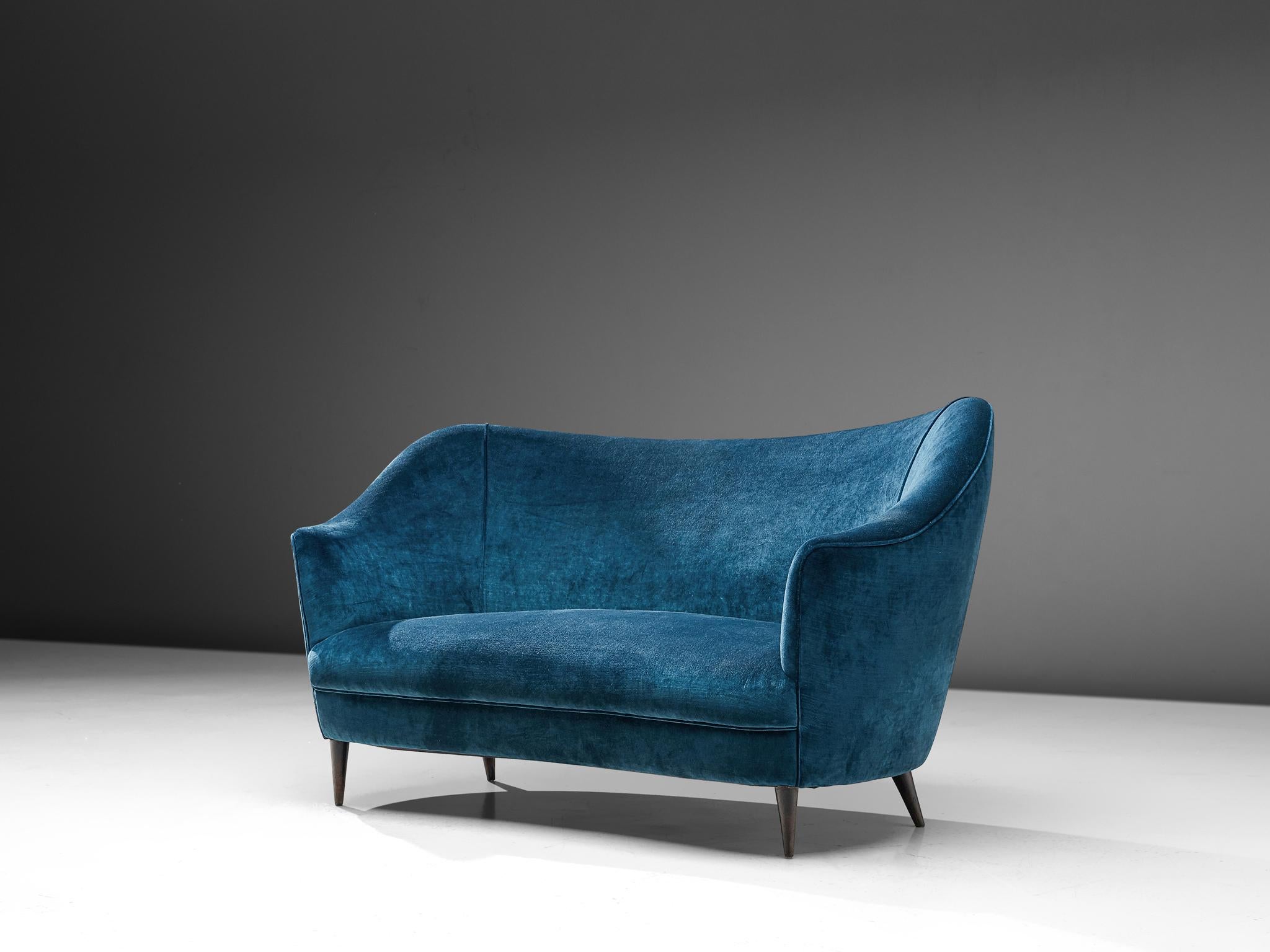 Sofa, wood and blue fabric, Italy, 1950s.

Two-seat Italian sofa in blue velvet upholstery. This sofa shows beautiful and elegant lines. The wide seating is executed with high armrests pointed up that give this settee an airy, frivolous look. The