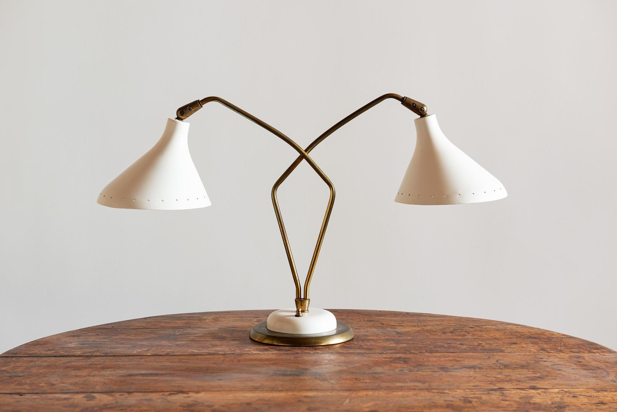 Elegant Italian table lamp with crossed brass necks and enameled cream shades perforated with small stars along the edge. Three settings, Italy, 1950s.