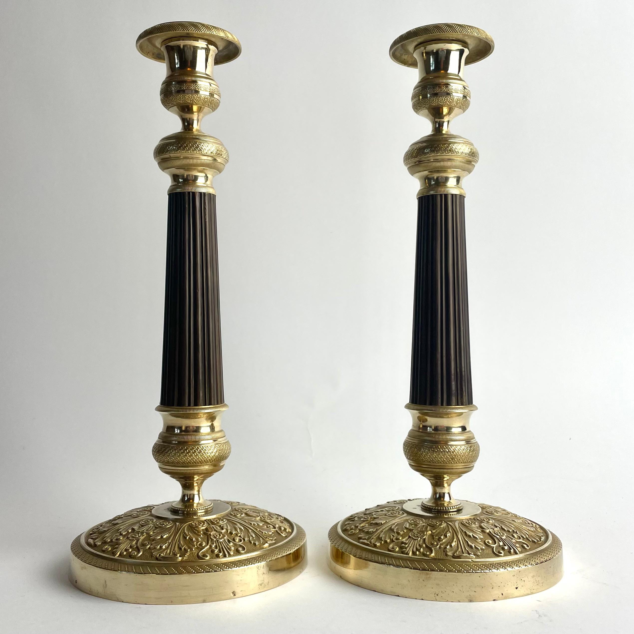 
Elegant Large Empire Candlesticks in Gilt and Patinated Bronze, France, 1820s

An elegant and imposing pair of Empire candlesticks, France, circa 1820, crafted in gilt and dark patinated bronze. Their tall and slender form, combined with the