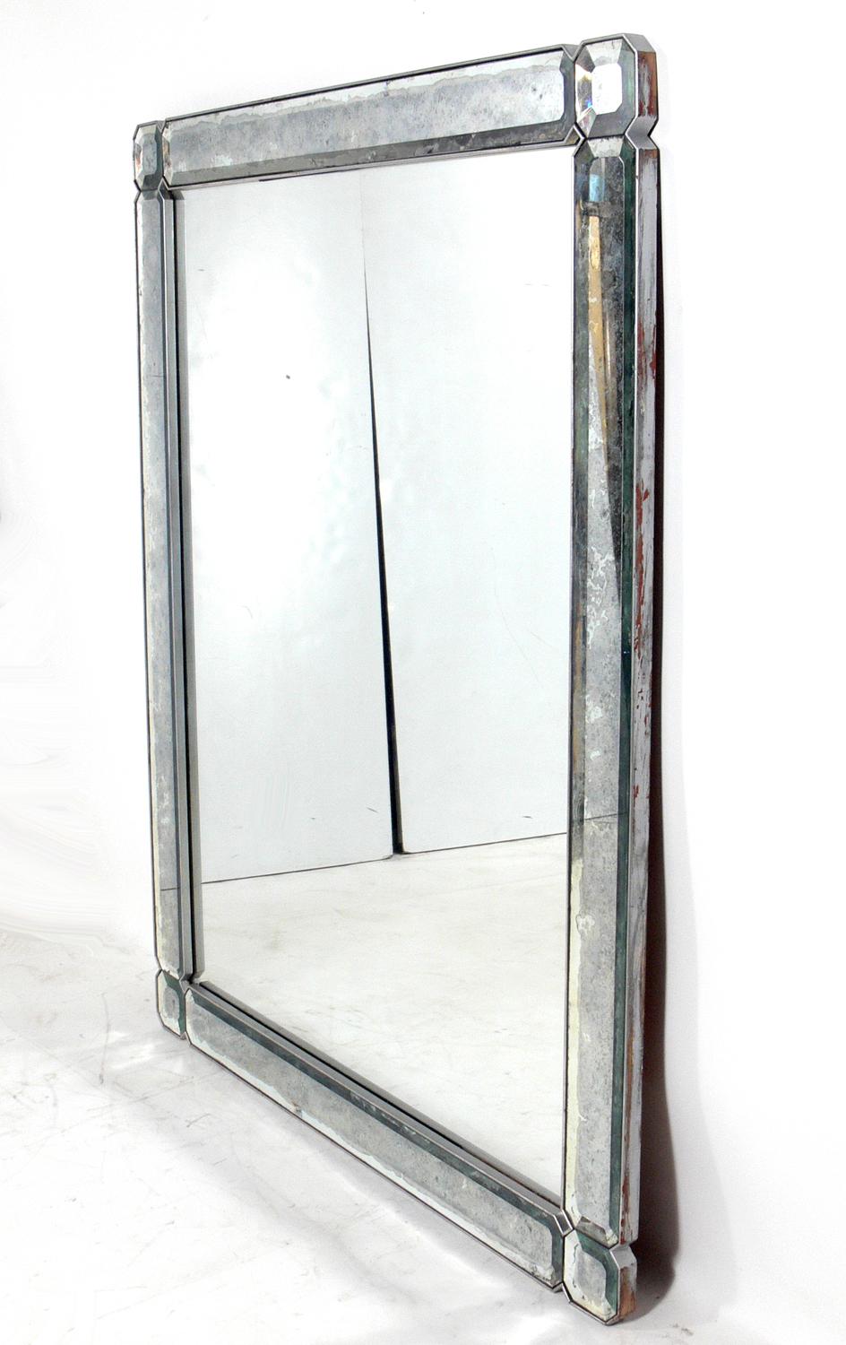 Elegant large scale mirror, probably Italian, circa 1950s. Wonderful original patina to both the mirrored portions and the silver giltwood frame. It measures an impressive 60