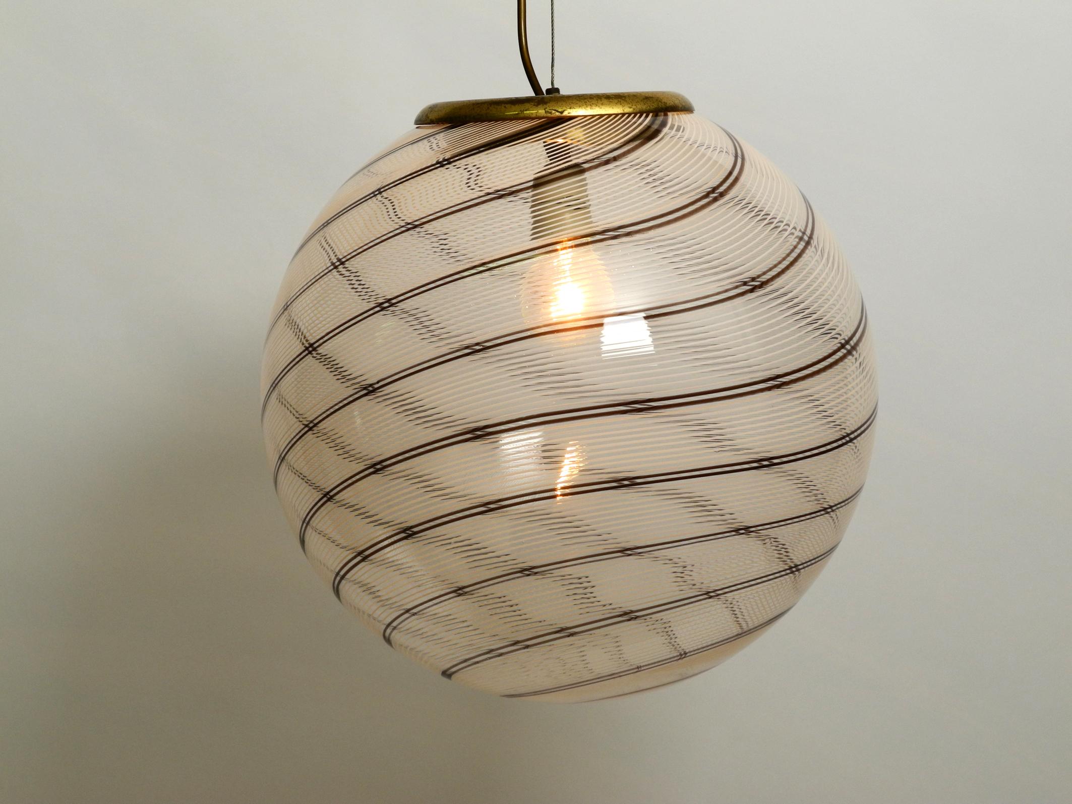 Beautiful large Italian Tessuto pendant lamp by Massimo & Lella Vignelli.
Made by Venini Italy from the 1970s.
Great Minimalist Italian design. Makes a very nice pleasant light.
The stripes on the wall only appear just with a clear glass light