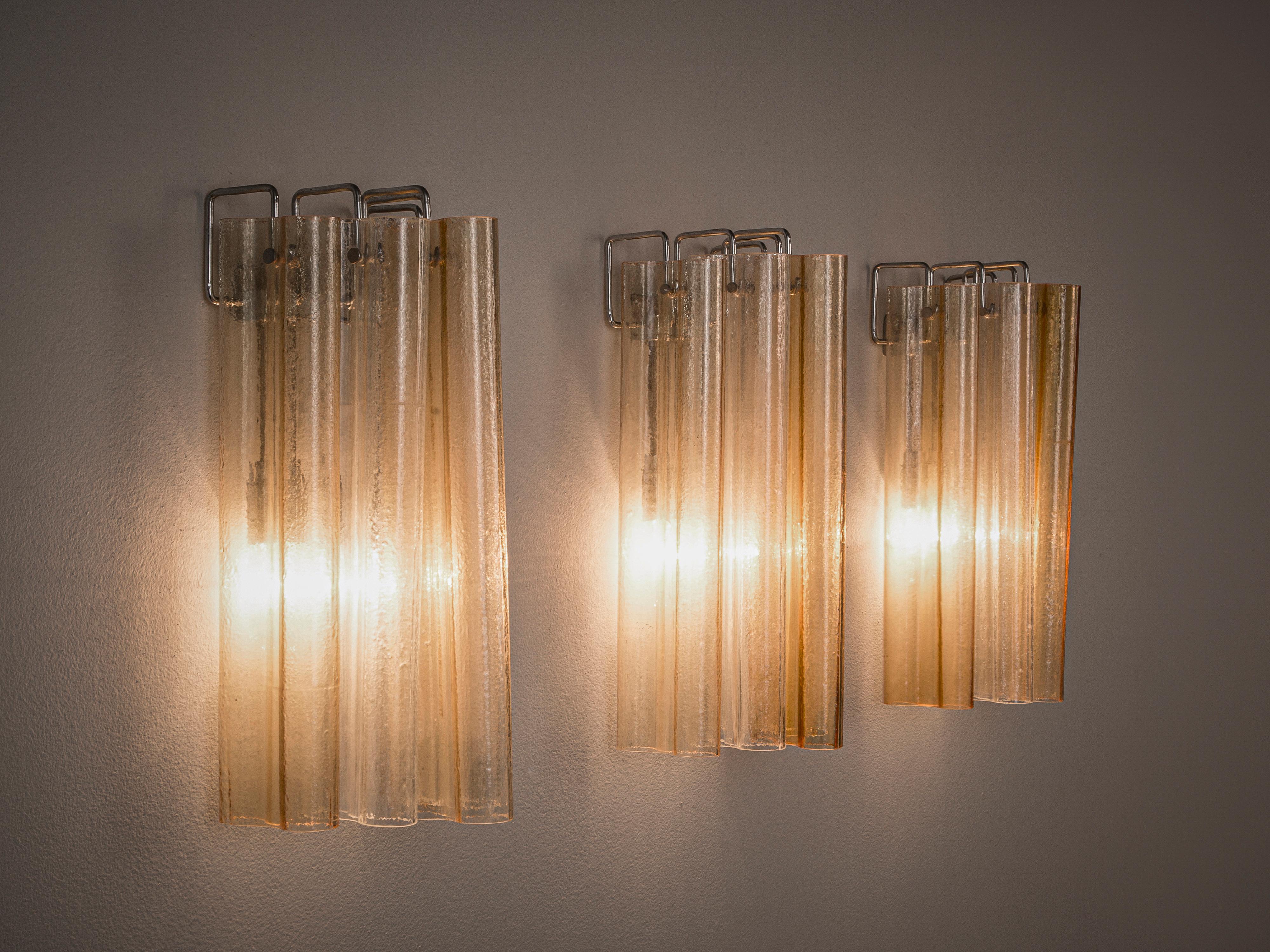 Wall lights, glass, metal, Italy, 1960s

These elegant wall lamps consist of five shades each. The long shades in the shape of an eight are adjusted around the light source. The light parts beautifully though the transparent and slightly orange