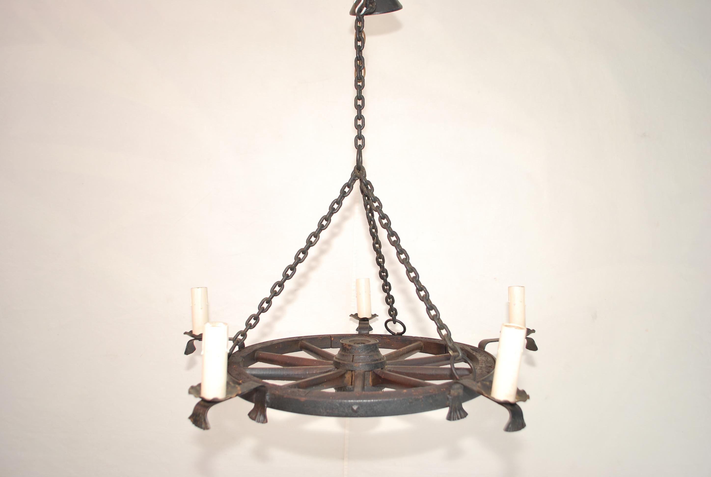 A very nice late 19 th century wagon wheel converted into a chandelier, please remember the wheel itself is late 19 th Century, the rest was done in the 1950's, it was custom made, if you need a rustic ambiance , this is the perfect chandelier, the