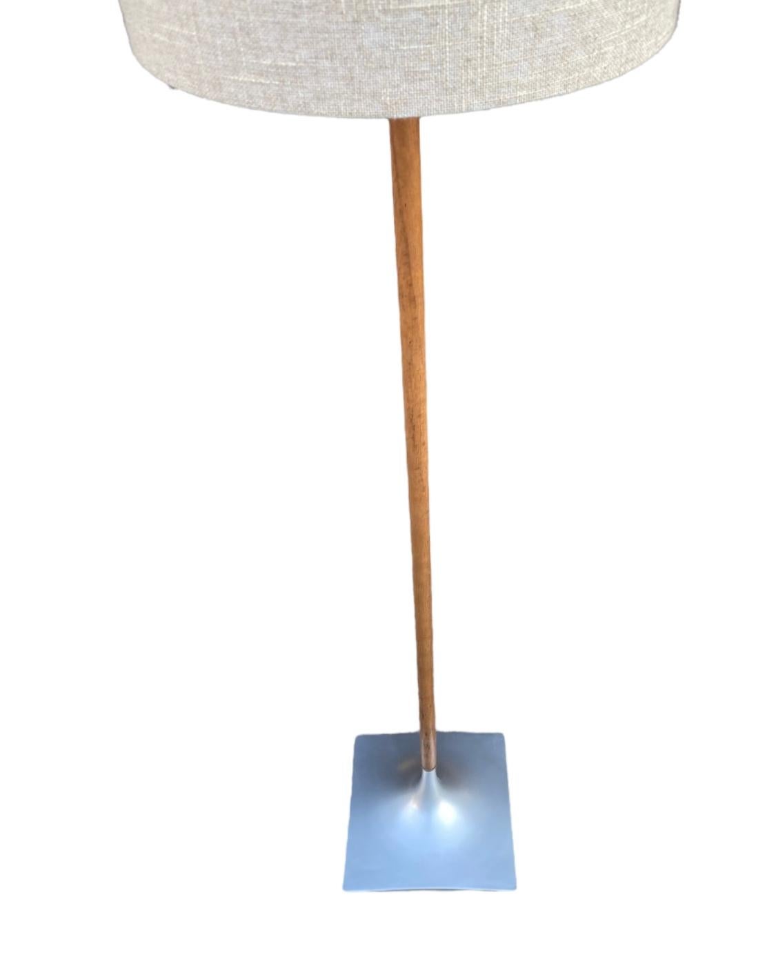 Beautiful walnut floor lamp by Laurel Lamp Company. Elegance from head to toe, featuring textured linen shade, walnut pole, and graduated tulip square base. Circa 1960s, with later barrel shade. In good condition with full function. Accommodates