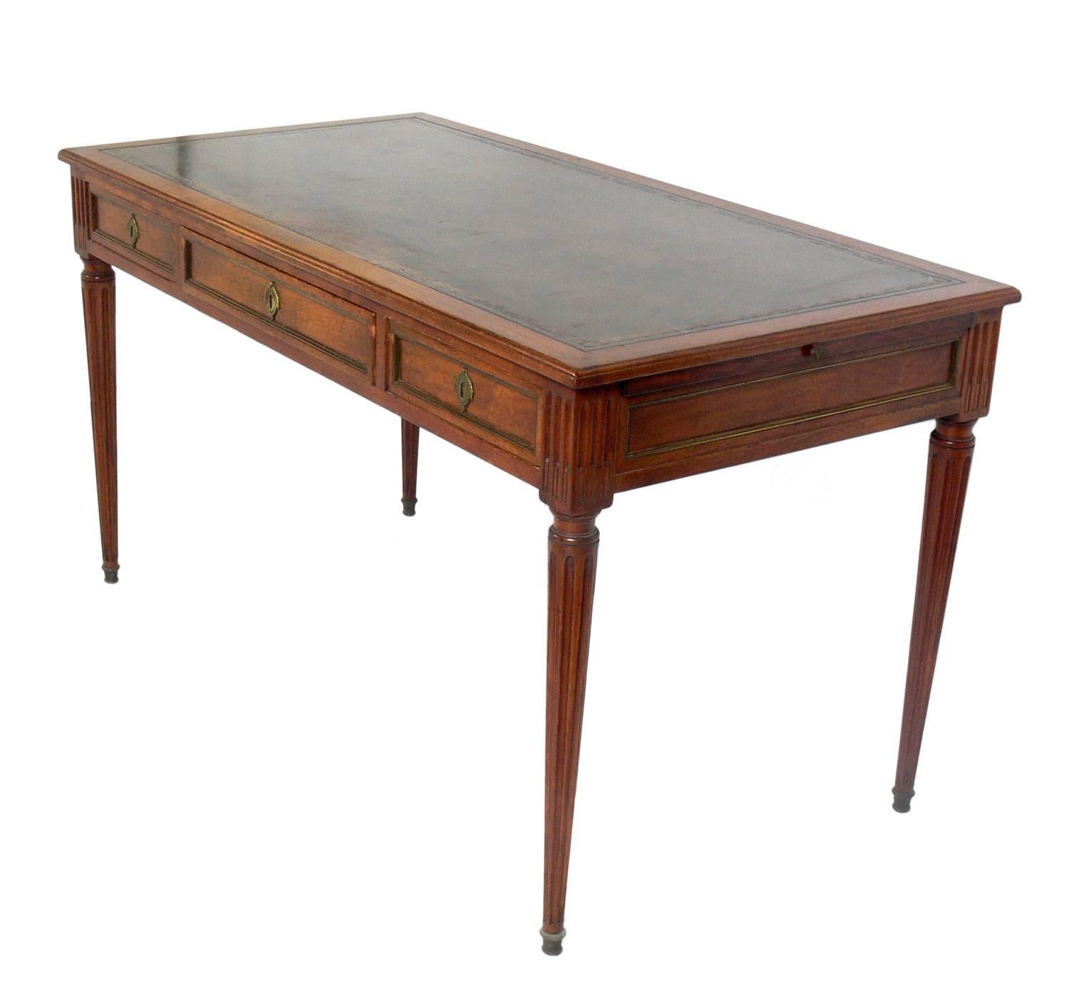 Elegant leather top French desk or bureau plat believed to be circa 1950s, possibly earlier. Imported by legendary NYC antique dealer Don Ruseau. It features an elegant leather top with embossed Greek key pattern.
