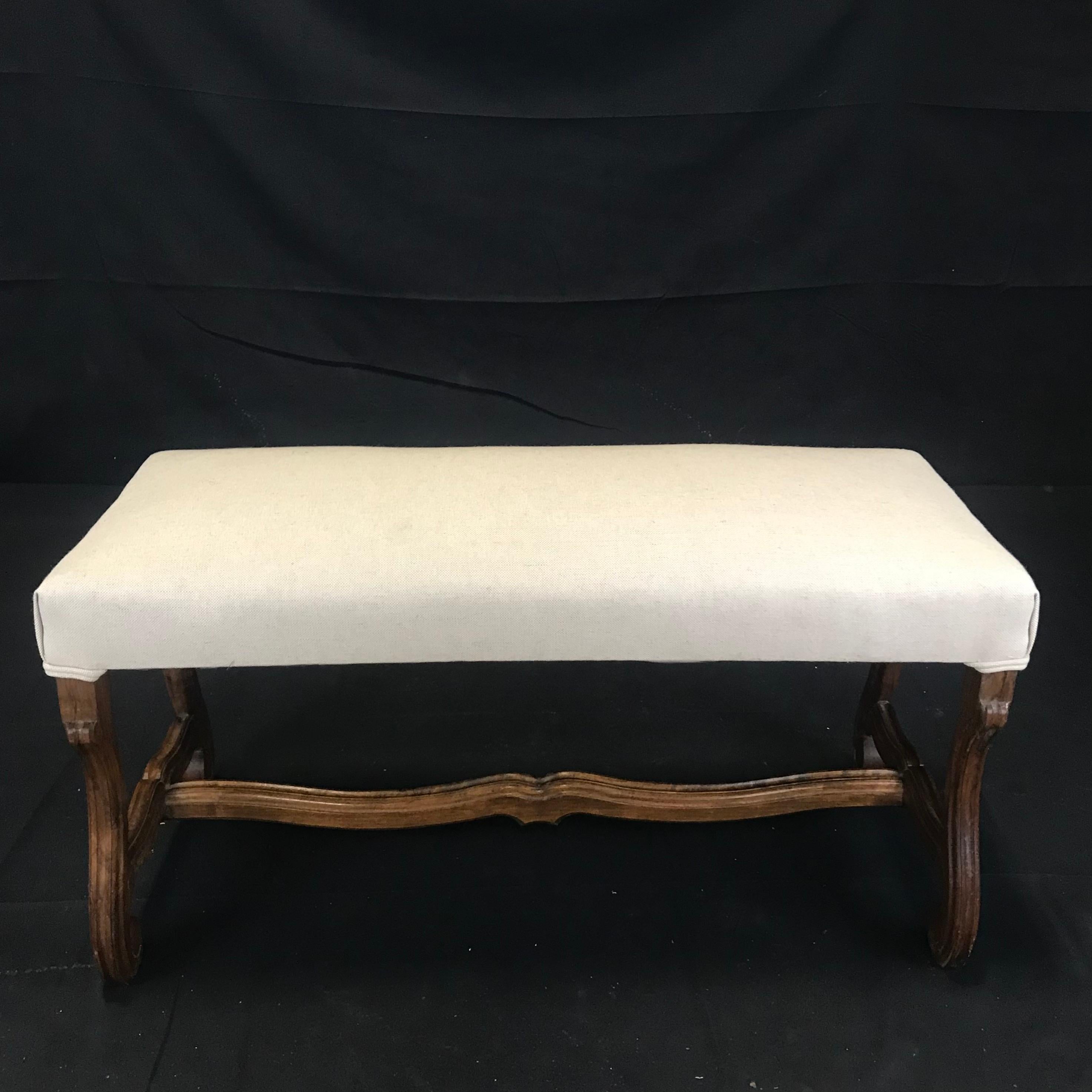 Great size and proportion in this Louis XIV beautifully carved walnut bench from the early 19th century. Rectangular carved frame fitted with newly upholstered boxed cushion in high end yet durable British linen cotton blend, H stretcher, and lovely