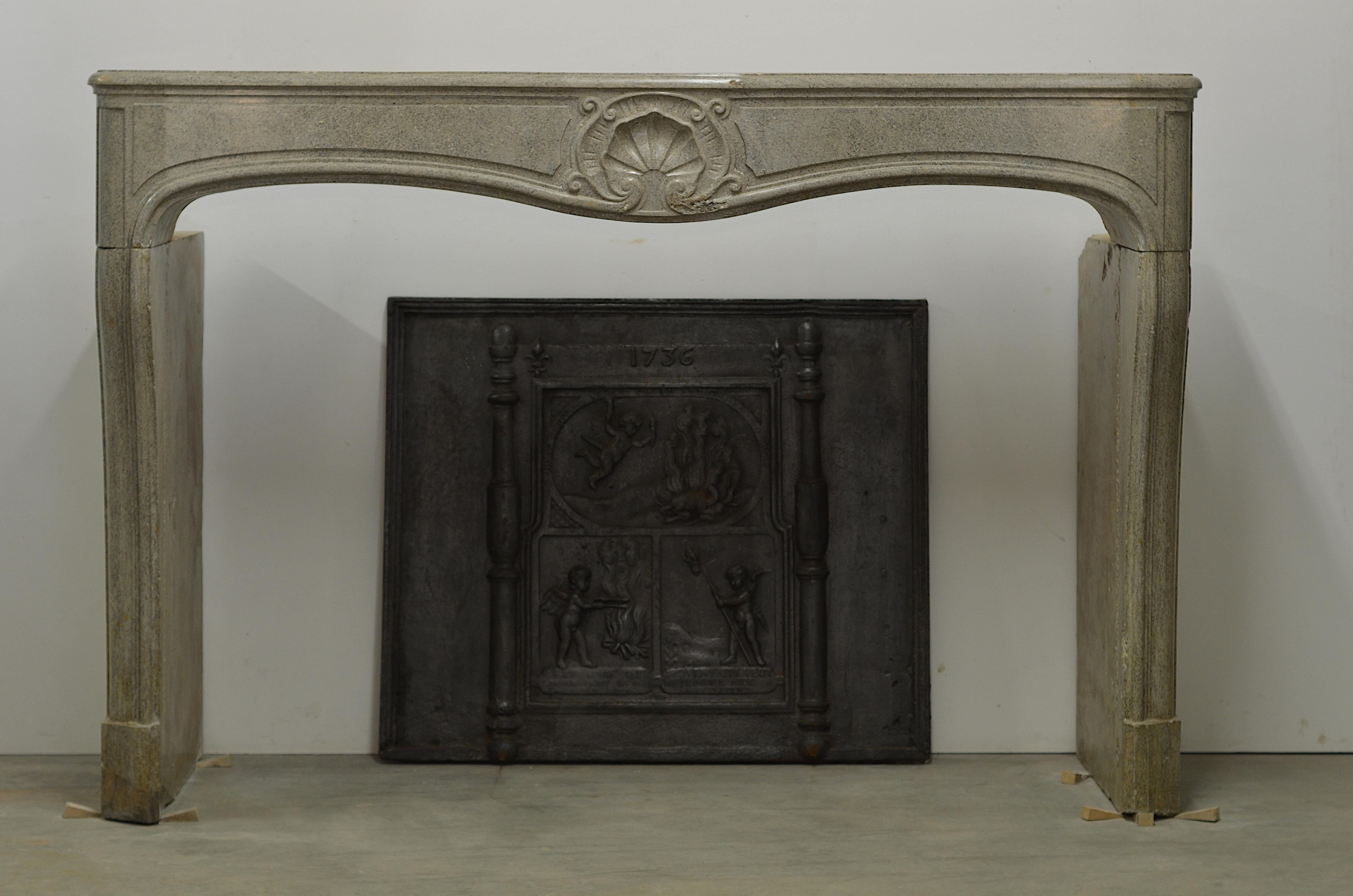 A nice French Louis XV fireplace in Buxy limestome.
This grayish fossilized stone has a lovely soft toned color suitable for almost every interior.

The elegant lines and simple but decorative carving make this a real treat, it still has its