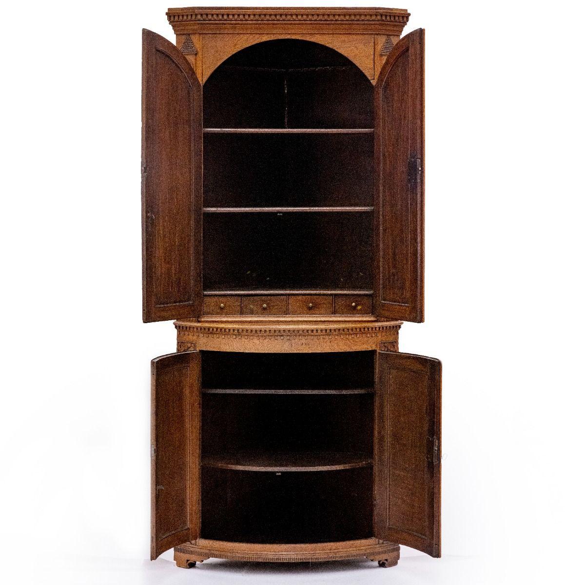 Louis XVI Corner Cabinet Crafted in Oak with Exceptional Cabinetmaking and Elegant Details
This exquisite cabinet consists of two parts: a base and an upper section.

The base features a curved front with dentil molding and triangular wood carvings