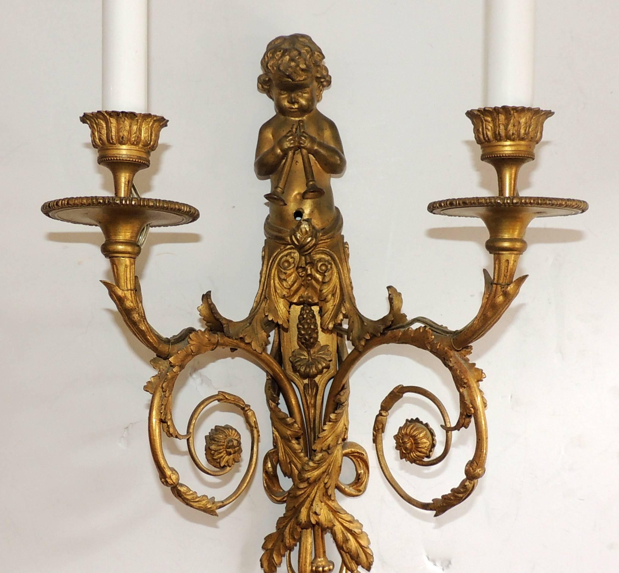 An elegant Louis XVI style pair of French gilt bronze cherub / putti playing flutes with filigree. Each sconces with two candelabra sockets, model after Jean Haure´.

Measures: 19