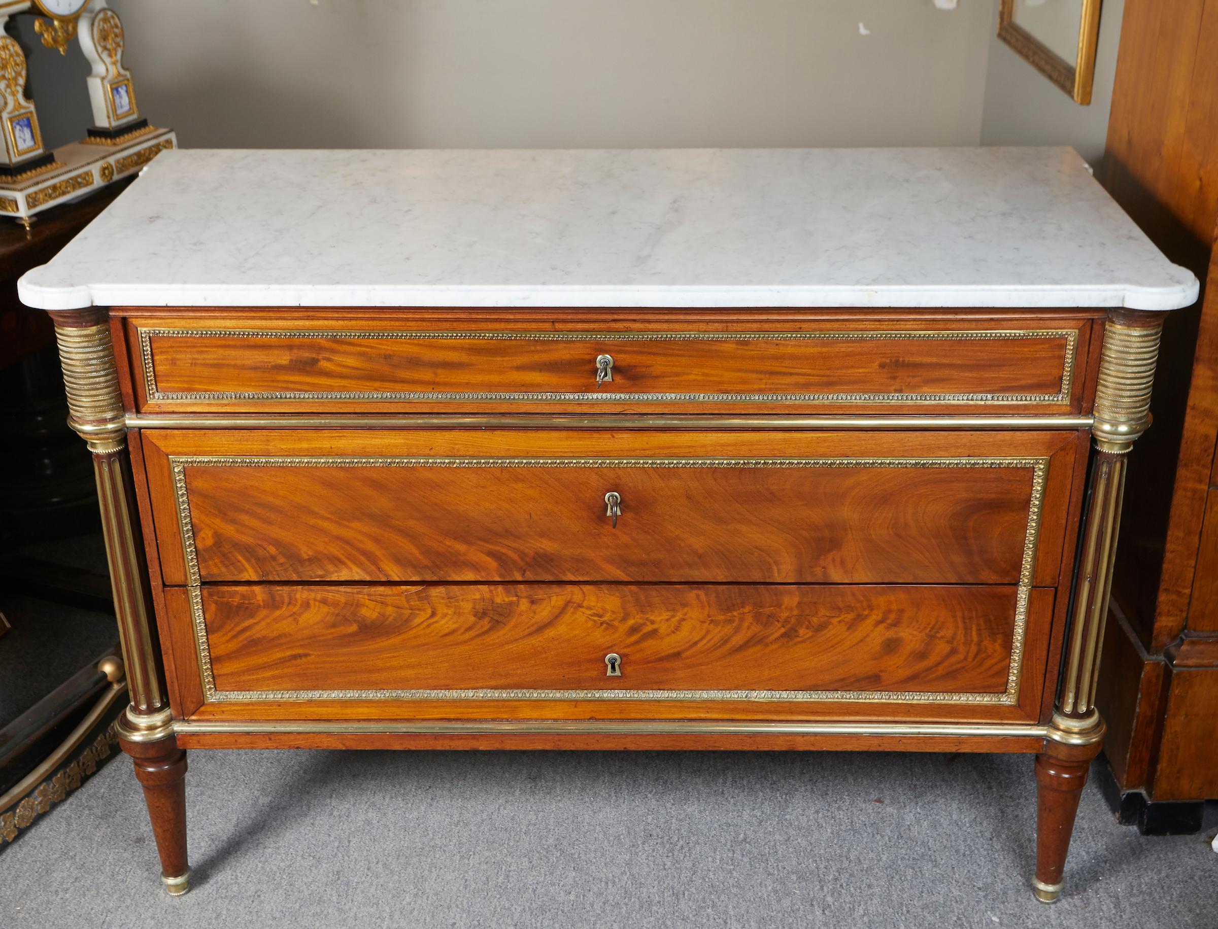 Elegant Louis XVI period flamed mahogany commode with white Carrara marble top.