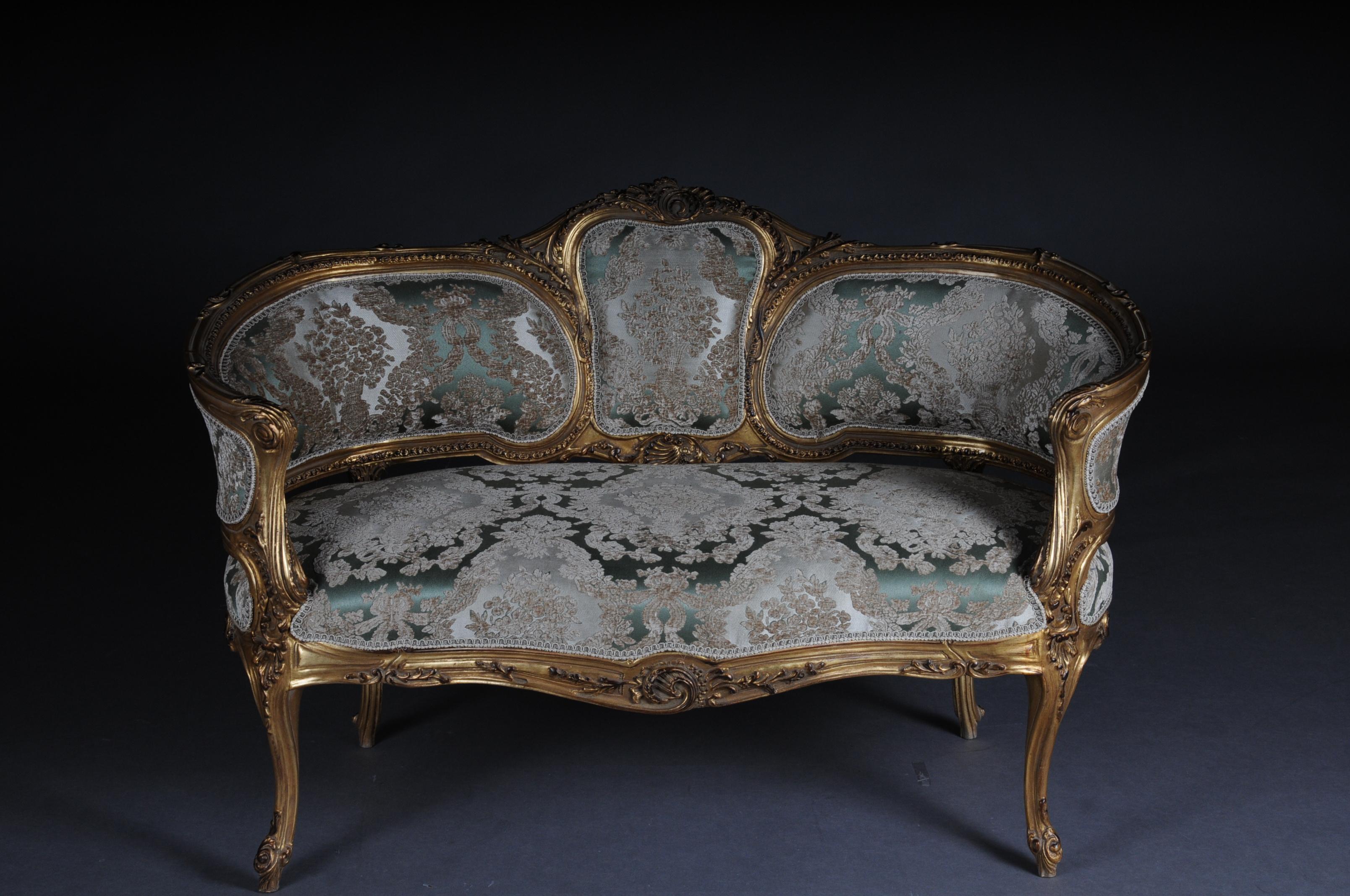 Solid beechwood, carved and gilt gilded. Semicircular rising, curved backrest framing with rocaille crowning. Appropriately curved frame with rich carved ornaments. Also decorated frame on curved legs. Seat and backrest are finished with a