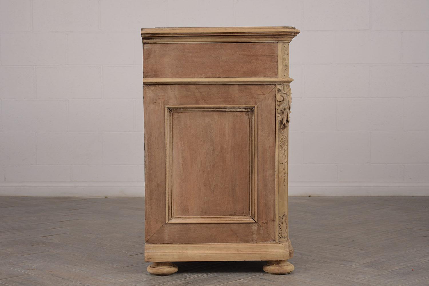 This is a 1880s French server or cabinet. Made from walnut wood, that has been bleached to show its natural wood color. Features an inserted black marble top with white veins. Top single long drawer with brass design handle and keyhole. Followed by