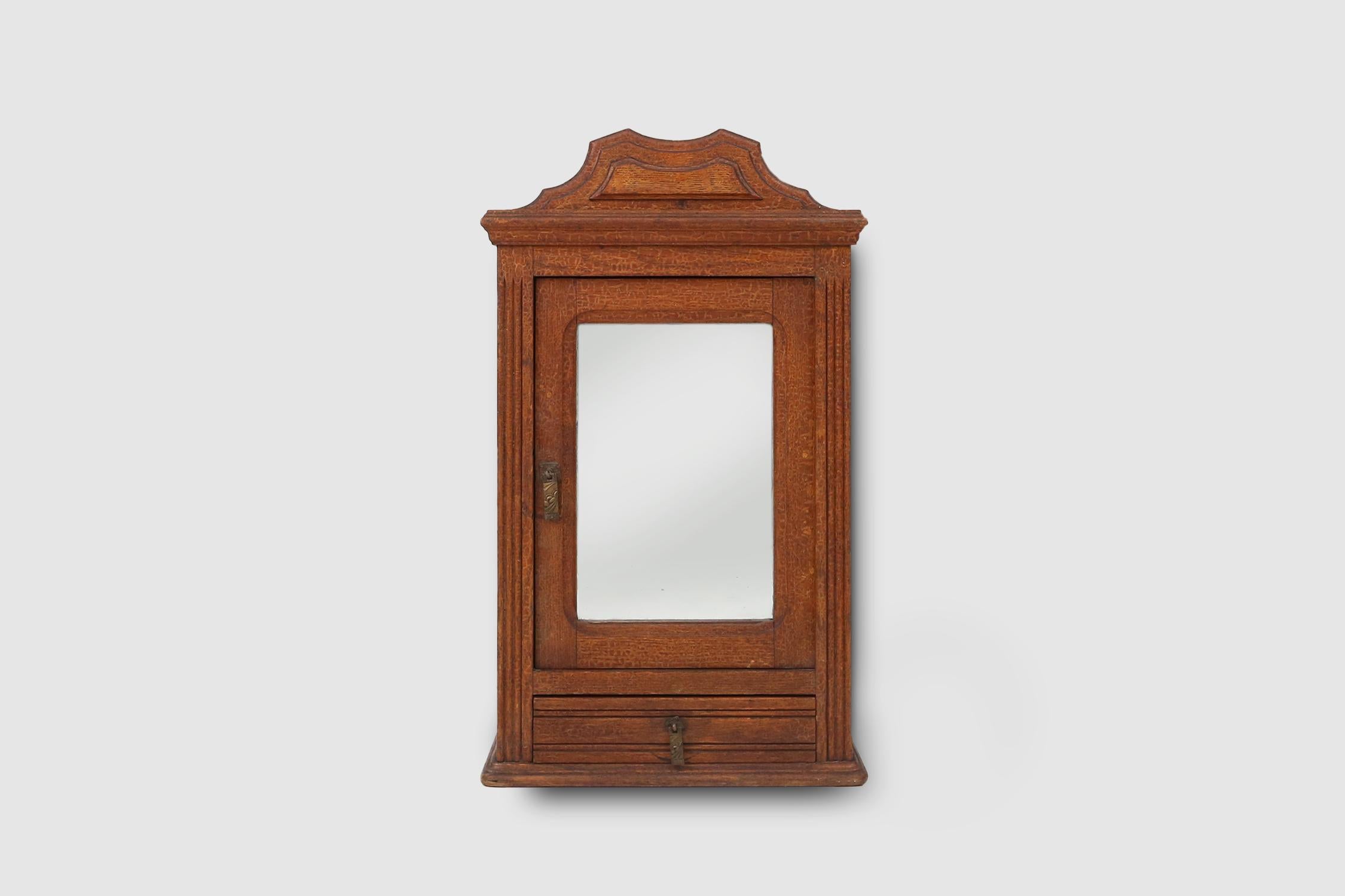 France / 1900 / medicine or shaving cabinet / wood and mirror / rustic / mid-century

Elegant medicine or shaving cabinet made in France, ca. 1900. The small cabinet has a mirrored door and a small drawer below. Both with beautiful art deco handles.