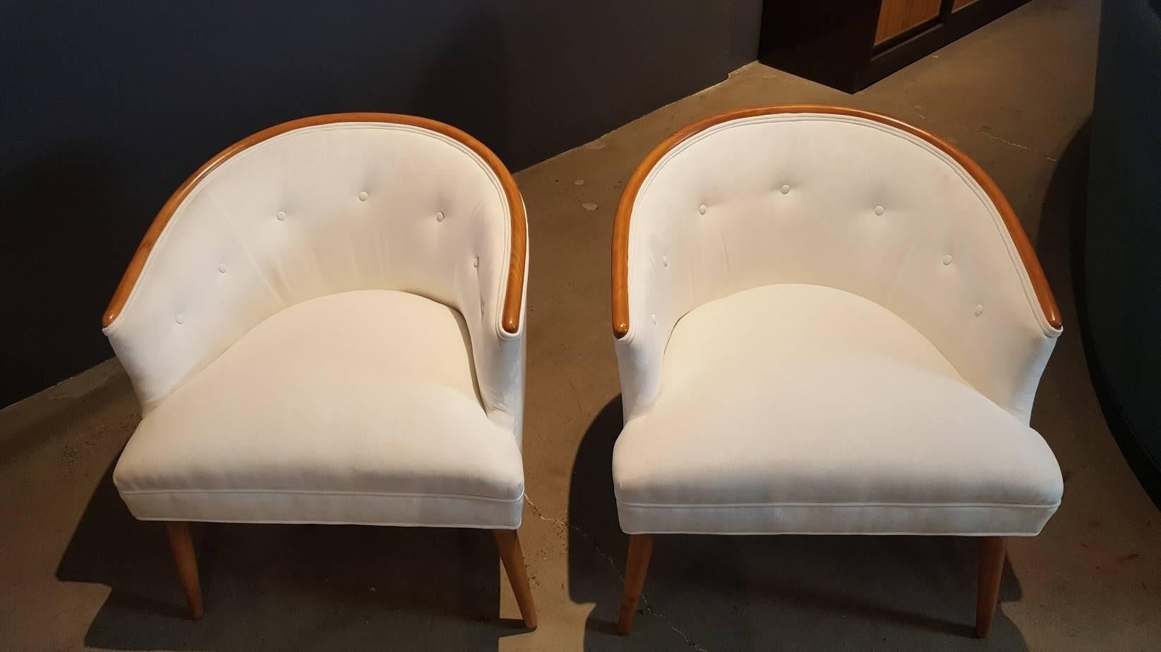 Sculptural, comfortable pair of Mid-Century Modern occasional chairs in the style of Harvey Probber or Paul McCobb. These have been fully restored with new foam and are reupholstered in a white cotton velvet. Mahogany band and splay legs have been