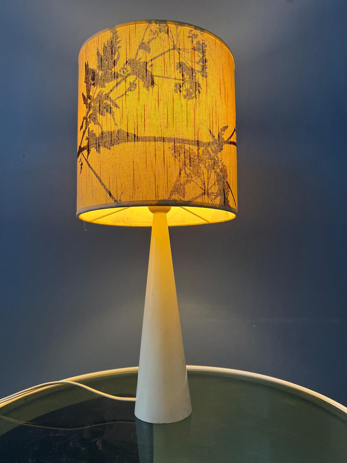 Elegant mid century table lamp with nicely decorated shade. The flower shade diffuses the light in a gentle and inviting manner, casting a warm and soothing ambiance. The lamp requires one E27/26 lightbulb and currently has an EU-plug (easily usable