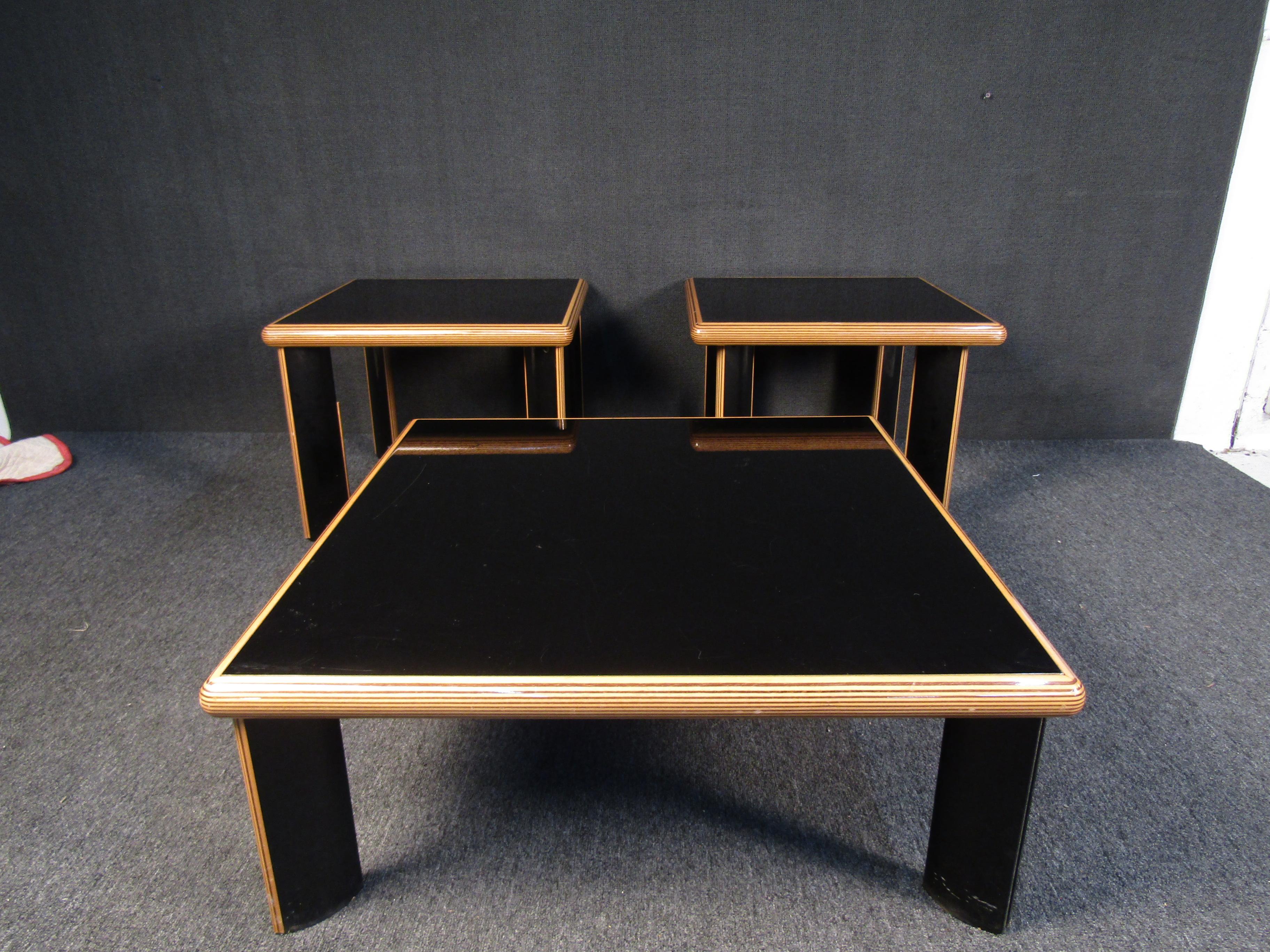 With an elegant black finish and light wooden accents, this set of one coffee table and two side tables is sleek and impressive. Please confirm item location with seller (NY/NJ).

Dimensions-
Coffee table: 38 W x 38 D x 15 H
Side table: 27 W x