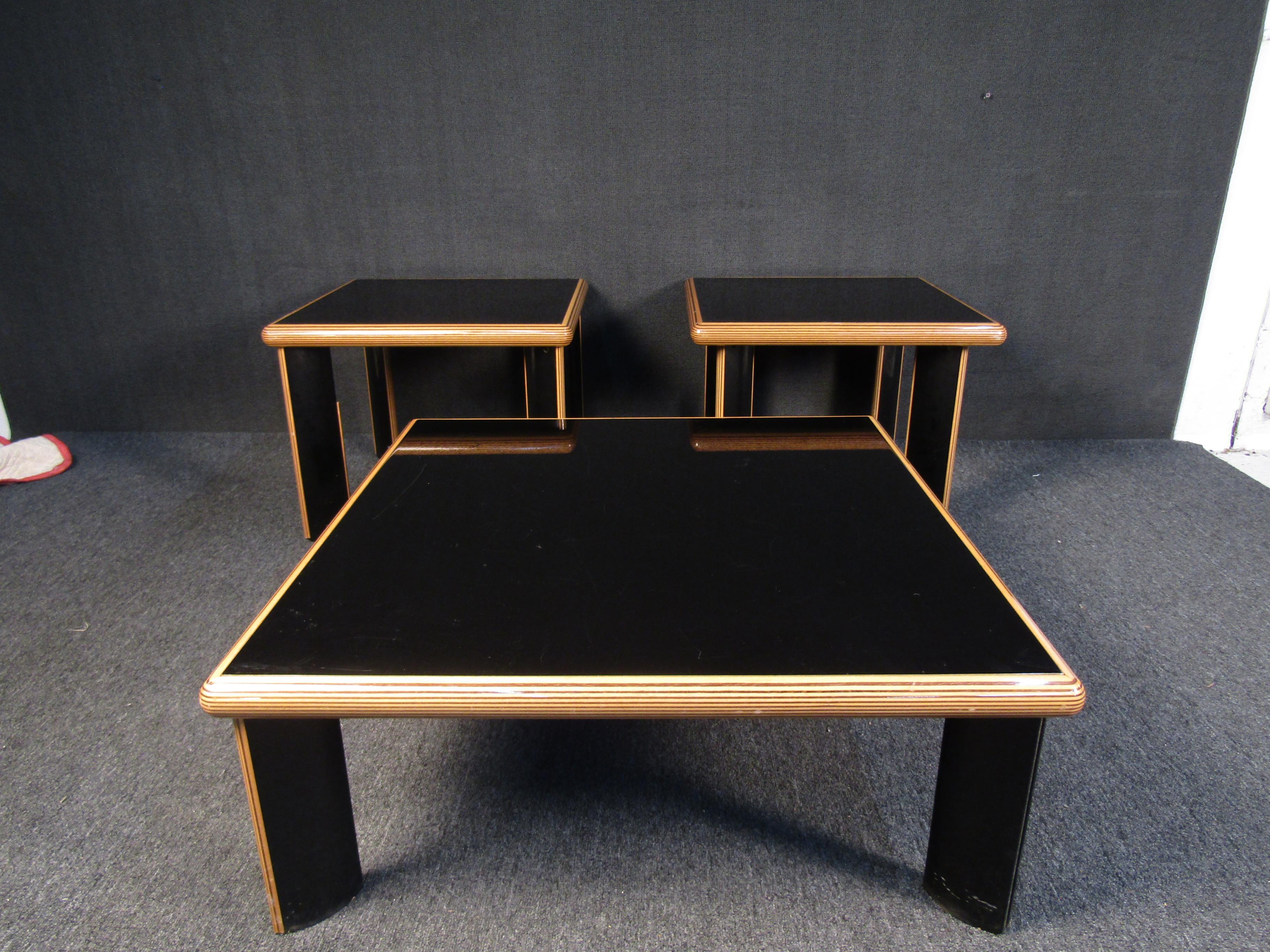 Avec une finition noire élégante et des accents en bois clair, cet ensemble composé d'une table basse et de deux tables d'appoint est élégant et impressionnant. Veuillez confirmer la localisation de l'article auprès du vendeur