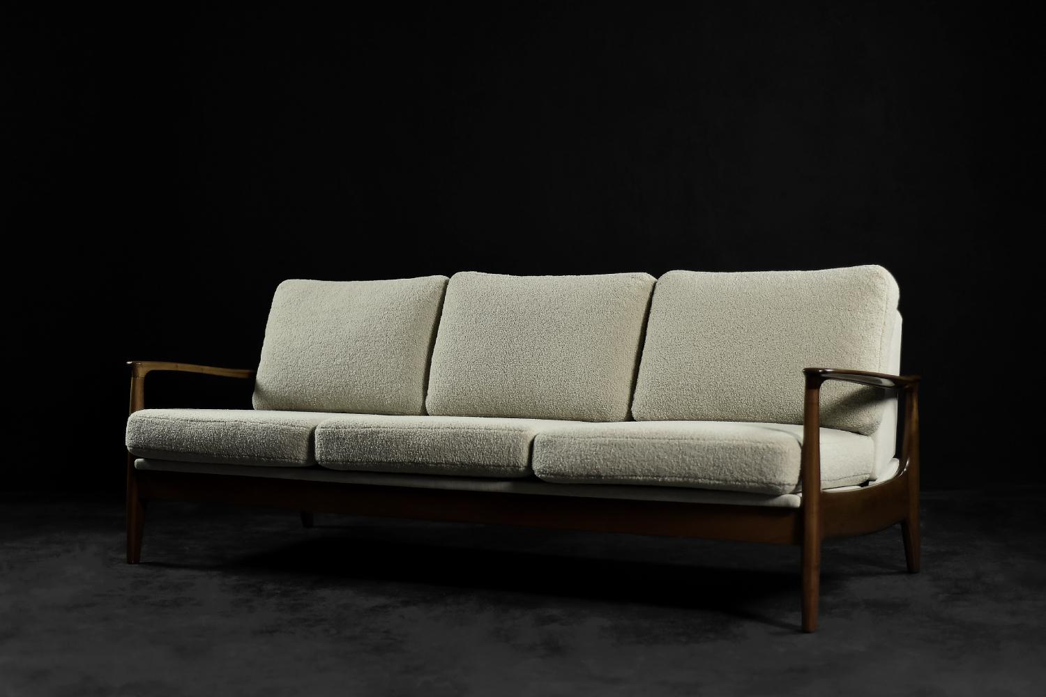 This elegant three-seater daybed was designed by Eugen Schmidt for the German Soloform factory during the 1960s. The organic frame is made of teak wood in a light shade of brown. The sofa has a simple spring mechanism that allows it to be unfolded