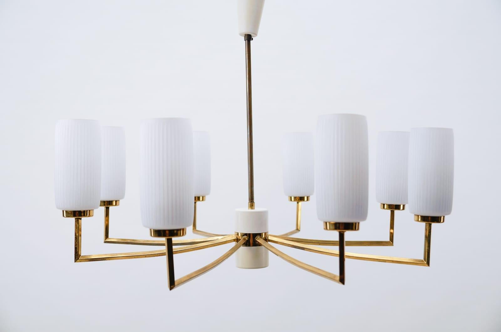 Elegant Mid-Century Modern chandelier. 

Executed in brass, metal and opaline glass. The chandelier needs 8 x E14 Edison screw fit bulb.

Fully functional.

Each E27 socket. Works with 220V and 110V.

Wiring is suitable for all countries.