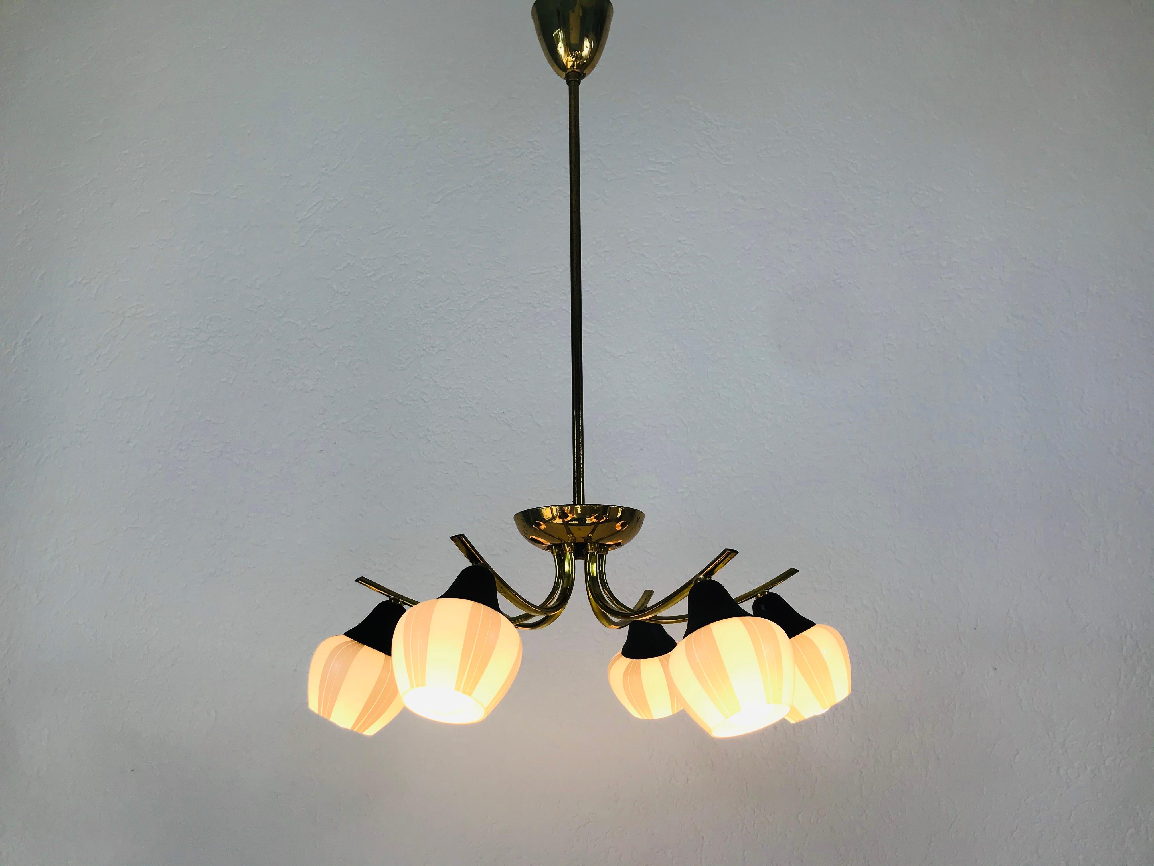 A midcentury chandelier made in France in the 1960s. Its very elegant and its design makes the light very exclusive. Six opaline glass shades.

Measurements:

Height 68 cm

Diameter 45 cm

The light requires six E14 light bulbs.