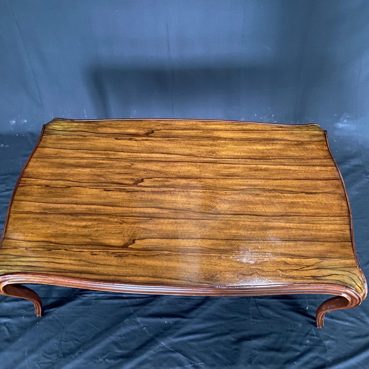 Lovely coffee table or cocktail table with sinuous curves by Keno Bros., for Theodore Alexander, recognized for their modern classic and mid-century modern styling. No longer made, this rosewood veneer table is made by Keno Bros., who specializes in