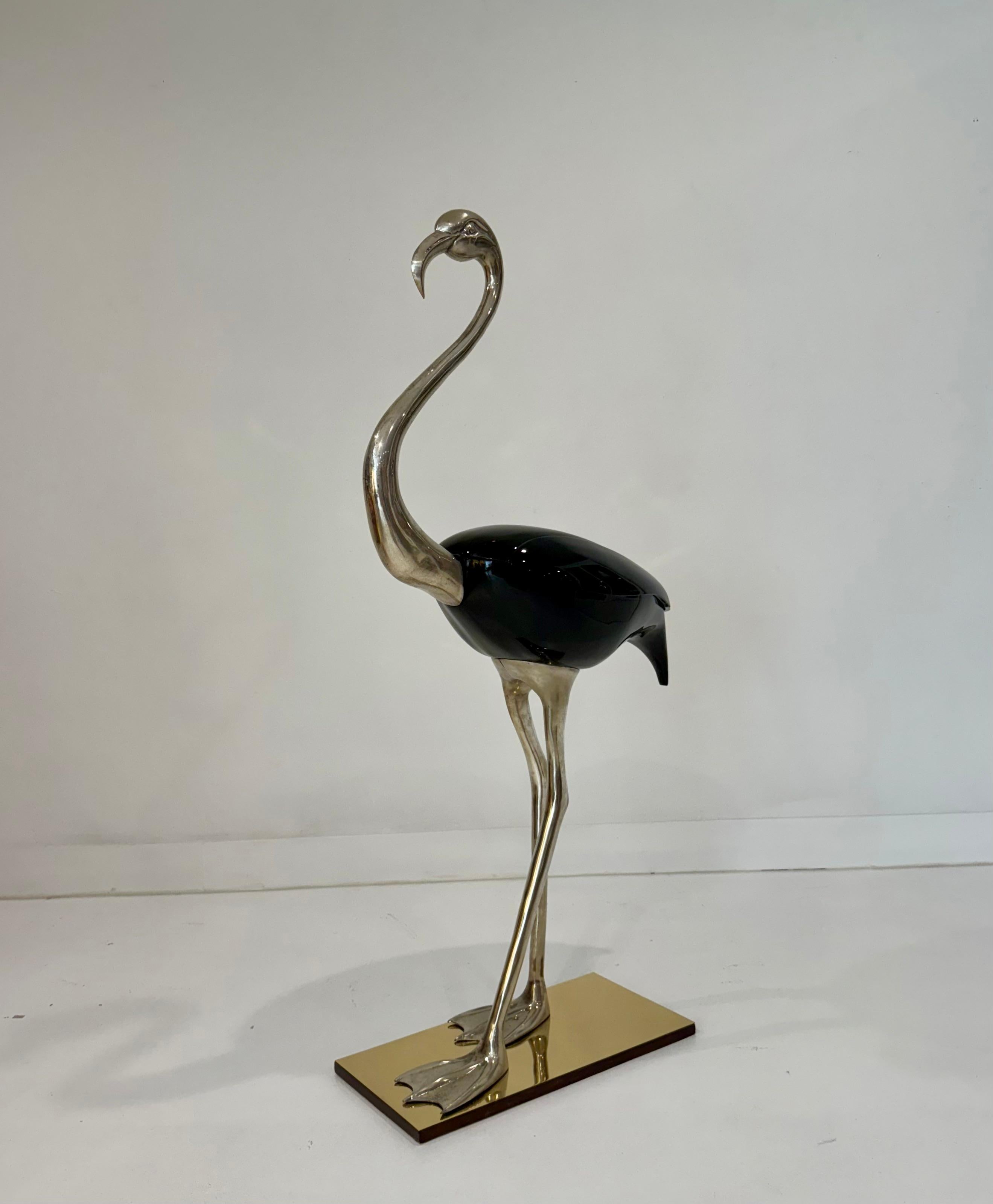 A refined and whimsical flamingo sculpture by Fondica France, celebrated for their imaginative and finely crafted decorative objects. This sculptural bird is rendered in warm silver plate with a high-gloss black enamel body, creating a striking