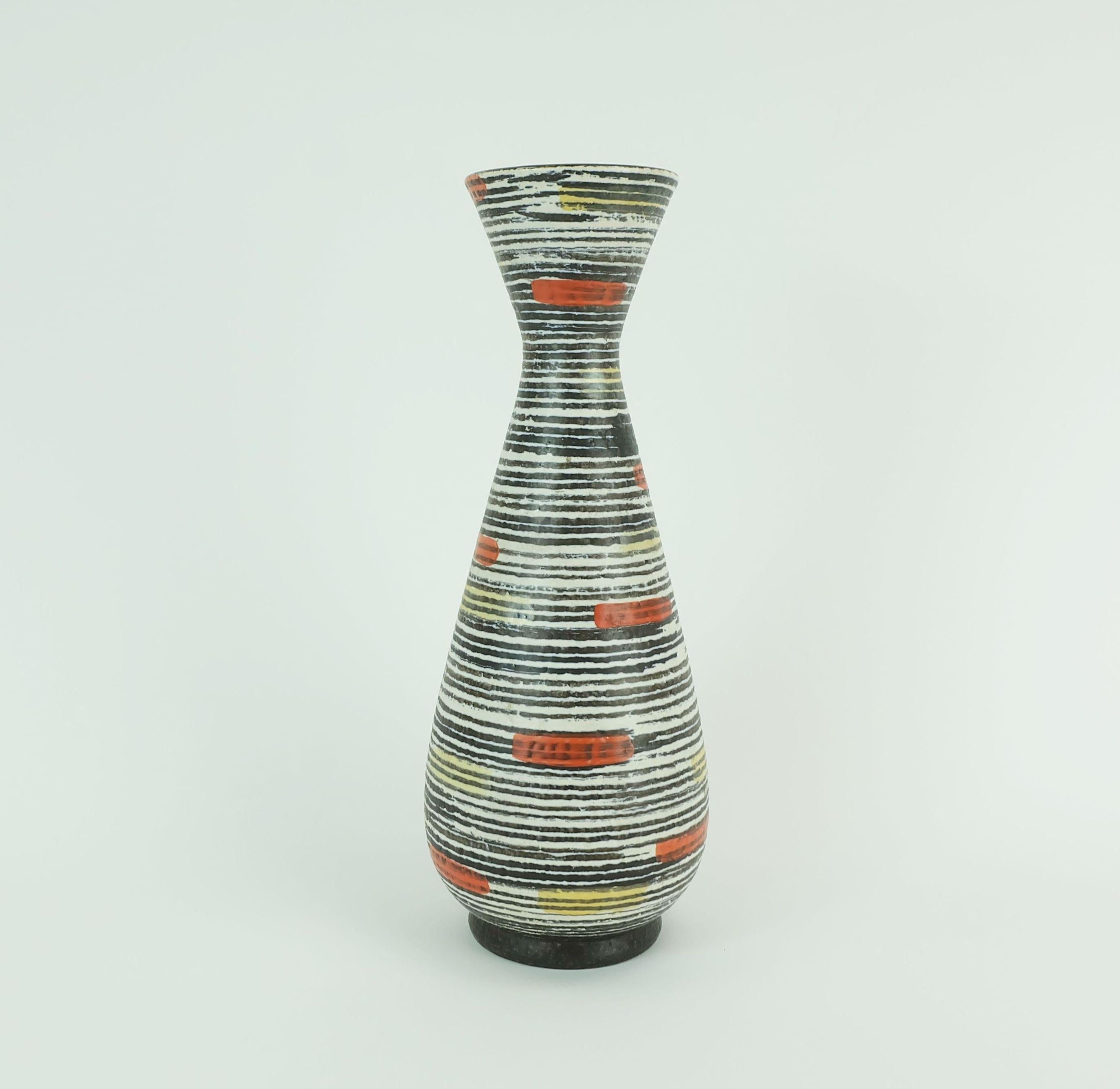 Bellissimo ed elegante vaso in ceramica della metà del secolo scorso prodotto da Jasba-Keramik nel 1960. Model 130/30. Motivo a righe in bianco e nero combinato con arancione e giallo.

Dimensioni in cm: 
Altezza 30,5 cm, larghezza 11