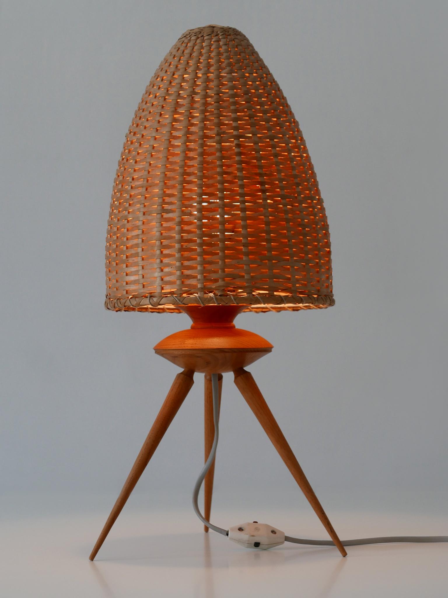 Rare and decorative Mid-Century Modern table lamp. Made probably in Scandinavia, 1960s.

Executed in teak and rattan, the table lamp comes with 1 x E27 Edison screw fit bulb holder. It is with original wiring, in working condition and run both on