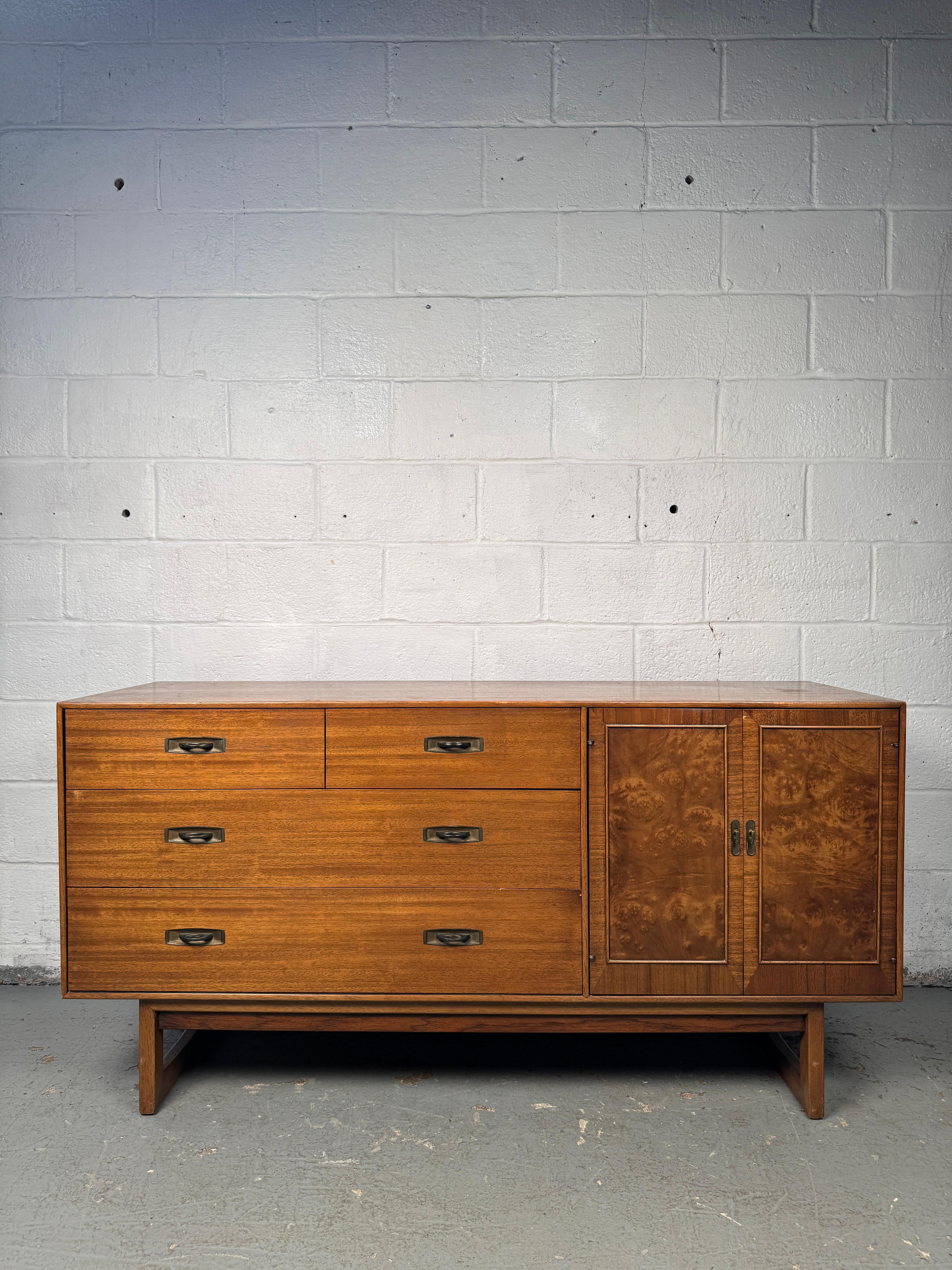 Sophisticated mid-century sideboard manufactured by Drexel, crafted in richly grained walnut. Features clean modern lines with ample storage, including drawers and cabinet space, all accented by the brand’s signature craftsmanship. A versatile and