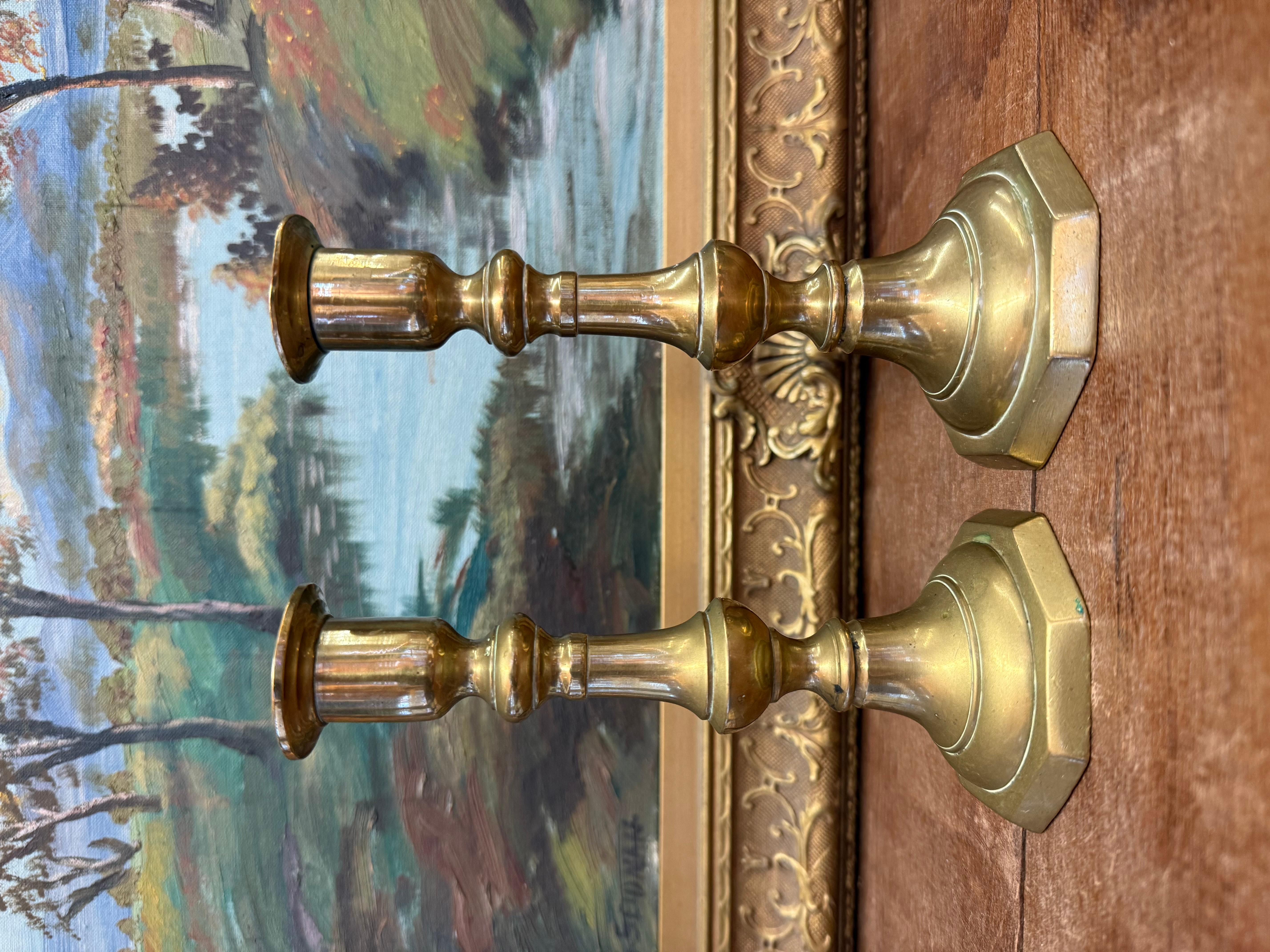L'arredamento consiste in una coppia di portacandele in ottone. Presentano un design classico con un corpo sottile e allungato e un'ampia base ottagonale. Ogni candeliere ha una parte superiore svasata in cui si trova la candela e la finitura in