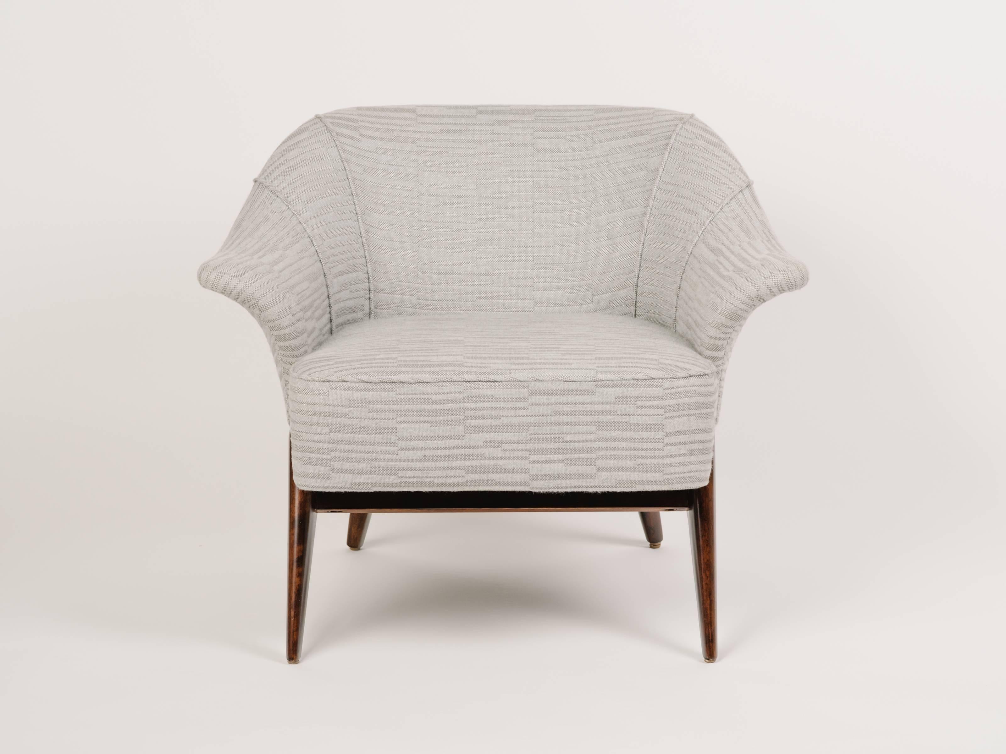 Outstanding Mid-Century Modern lounge chair with sculptural form. The chair has barrel form with winged swan sides and striking maple wood frame. Newly restored and upholstered in woven and embossed cotton-wool fabric with geometric pattern in light