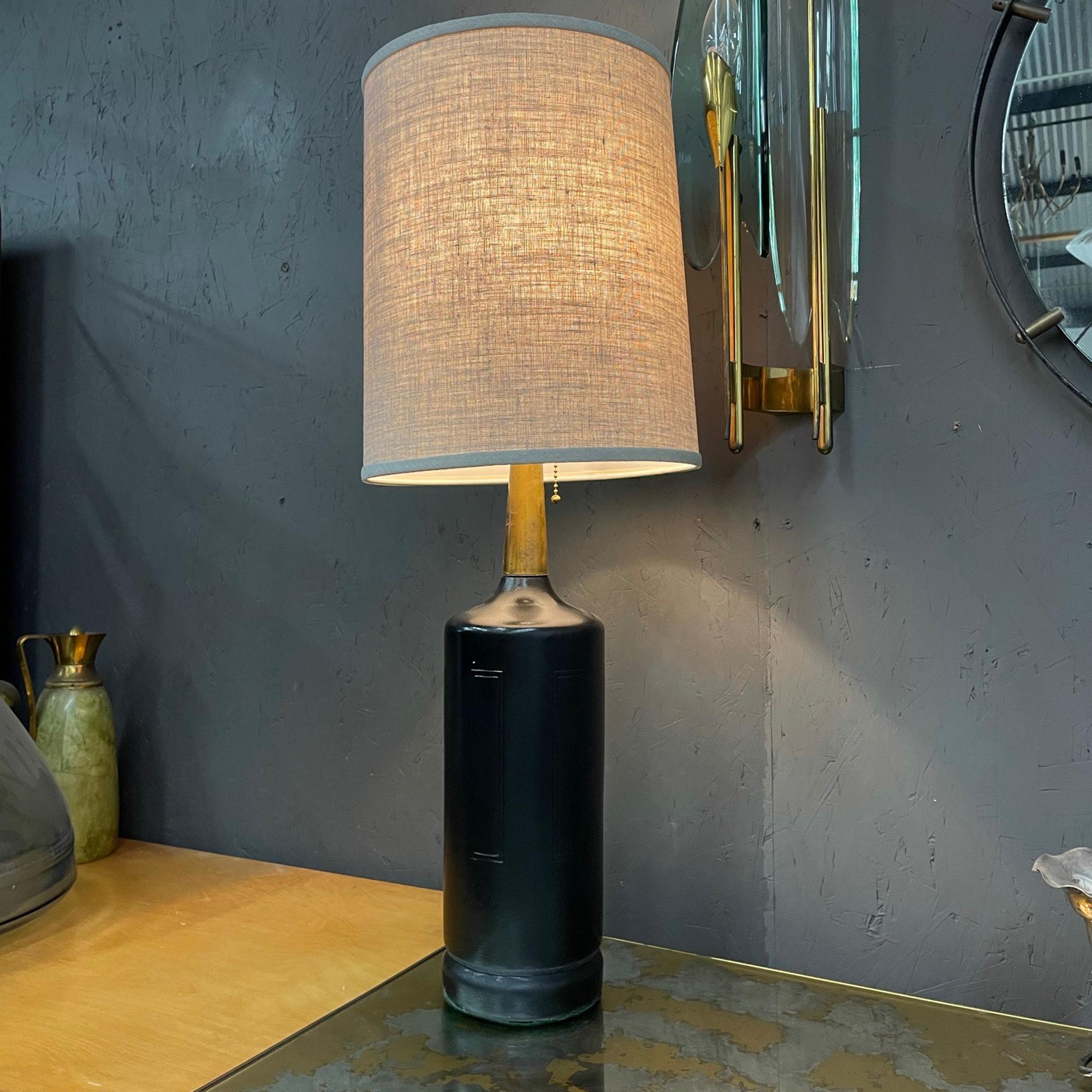 For your consideration an elegant Mid-Century Modern table lamp black and gold.
Made in the USA circa the 1970s. Clean modern cylinder design in black semi-gloss finish. Top section has a brass cone with original vintage unrestored patina. 

No