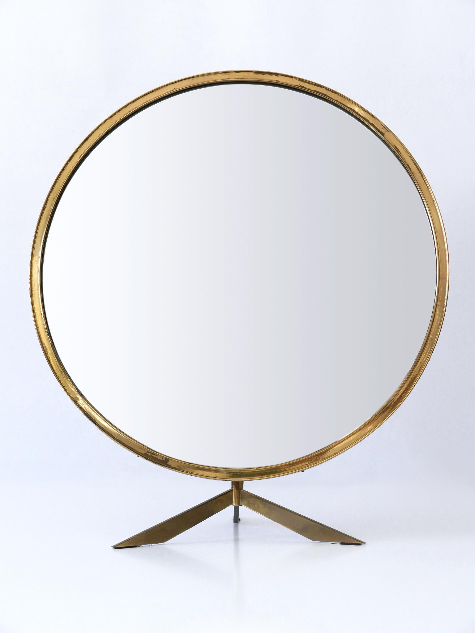 Rare and elegant Mid-Century Modern table / wall mirror with elegant brass and foot. Adjustable angle if used as table mirror. Manufactured by Münchner Zierform, Germany, 1950s.

Executed in mirror glass, brass and plywood.

Condition:
Good original