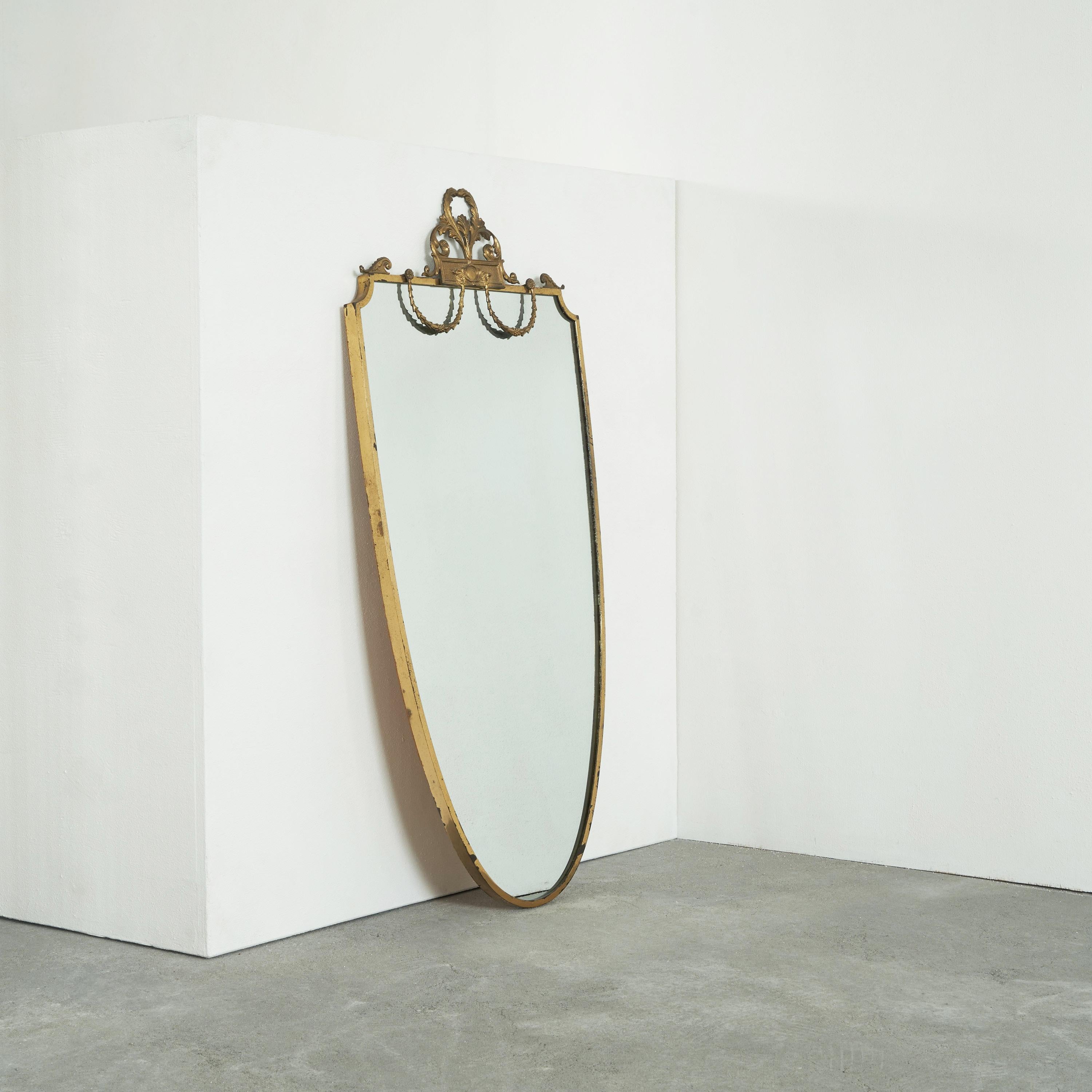 Elegant Mid Century Neoclassical mirror in Patinated Brass. Mid 20th century.

Very stylish and elegant wall mirror in patinated brass in a distinct neoclassical style. It has a very high class appearance due to the overall shape and wonderful