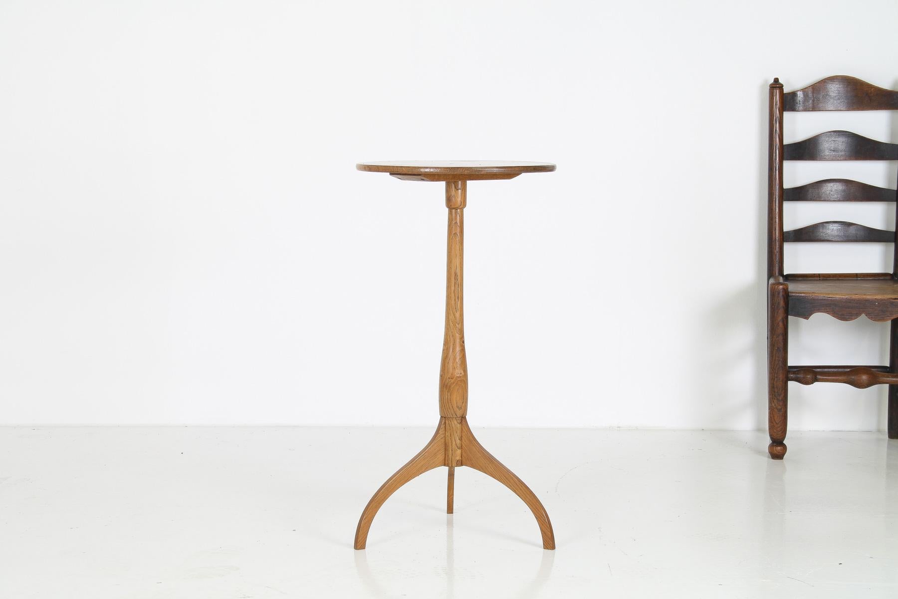 This beautifully crafted mid-century side table features a light oak finish and a round top with a stunning figure oak grain pattern. Despite its delicate appearance, the table is remarkably stable and strong, making it perfect as a side table or