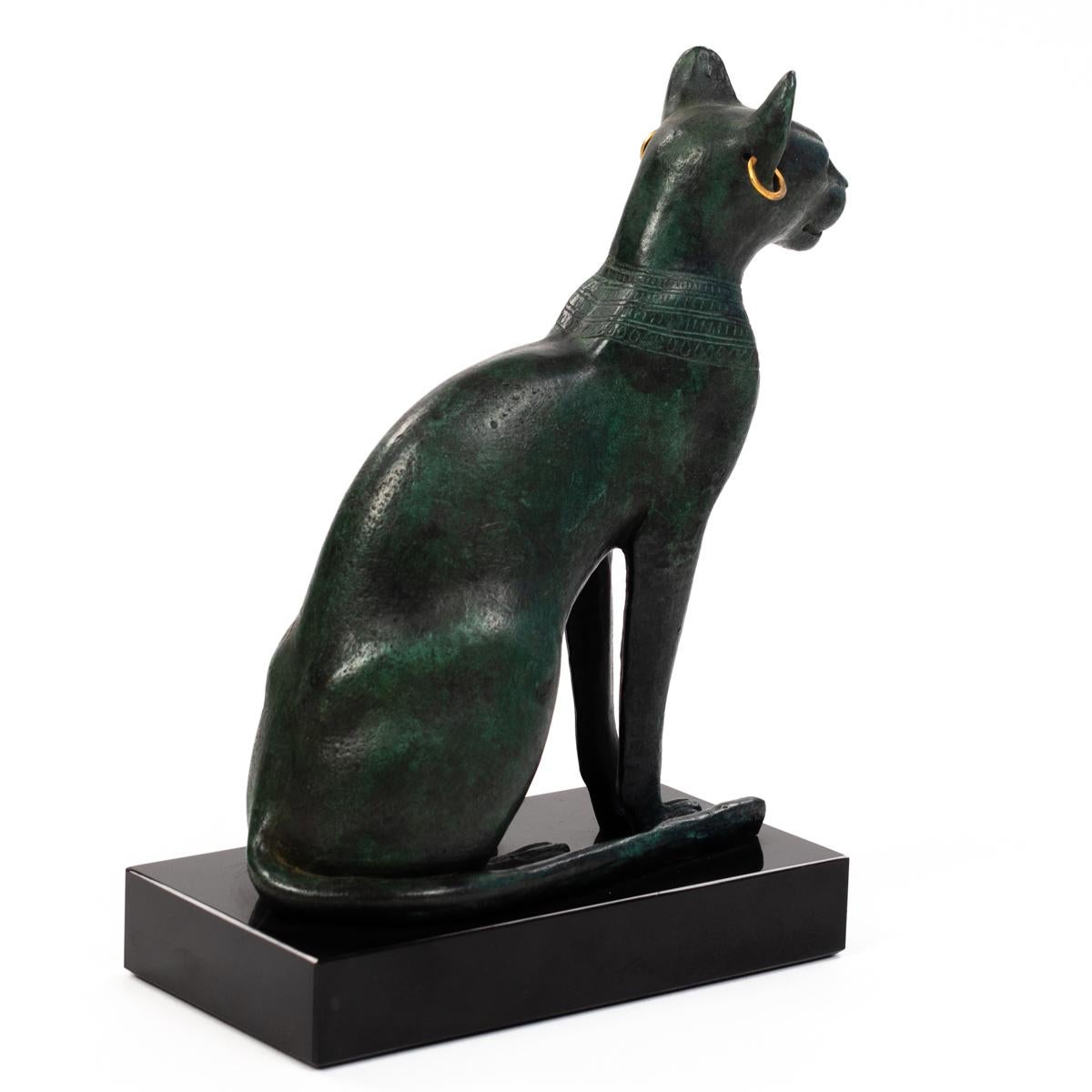 Elegant midcentury sitting bronze bastet sculpture, France, 1960s.

The Bastet cat god sits elegantly and straight on a black marble base. The tail lies resting nestled against the body next to it. Several surrounding decorative bands nestle along