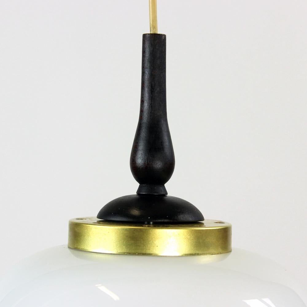 Beautiful, elegant ceiling pendant with two lights. Produced in 1960s in Czechoslovakia. The light has a wooden base on which two lights are hanging on a different lenght. The lenght of these cabels can be adjusted if needs to, right now it is 70cm