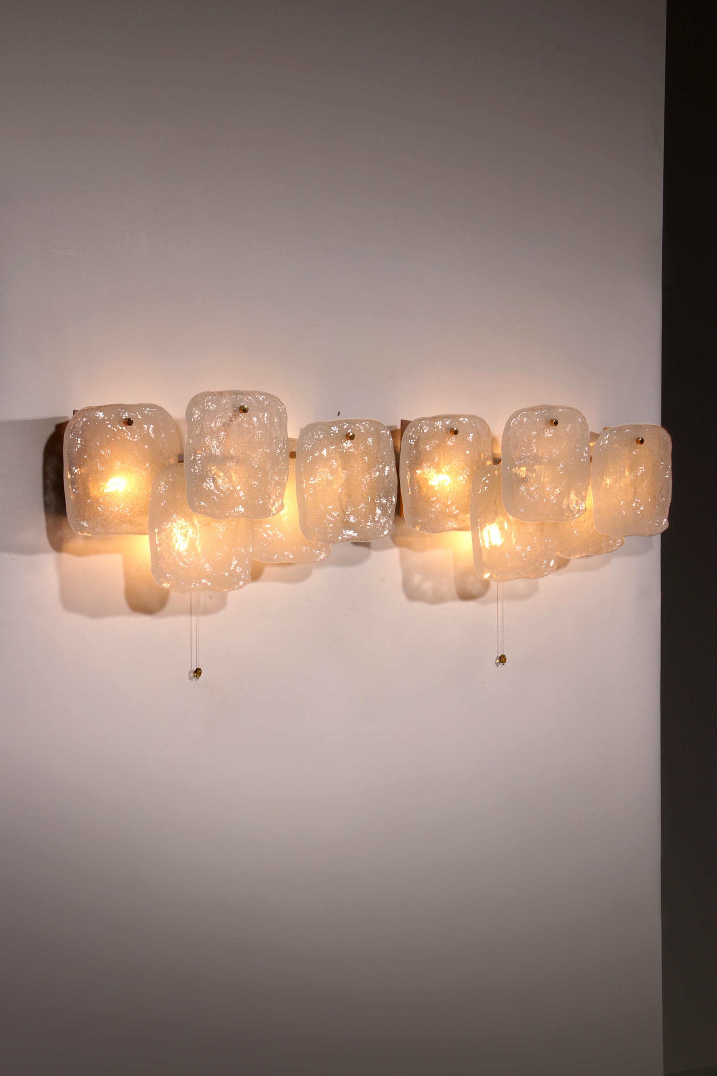 Cet ensemble de trois superbes appliques murales en verre glacé du milieu du siècle, conçues par J.T. Kalmar et fabriqué par Kalmar Franken en Autriche dans les années 1960, est un exemple de savoir-faire intemporel. Chaque applique comporte cinq