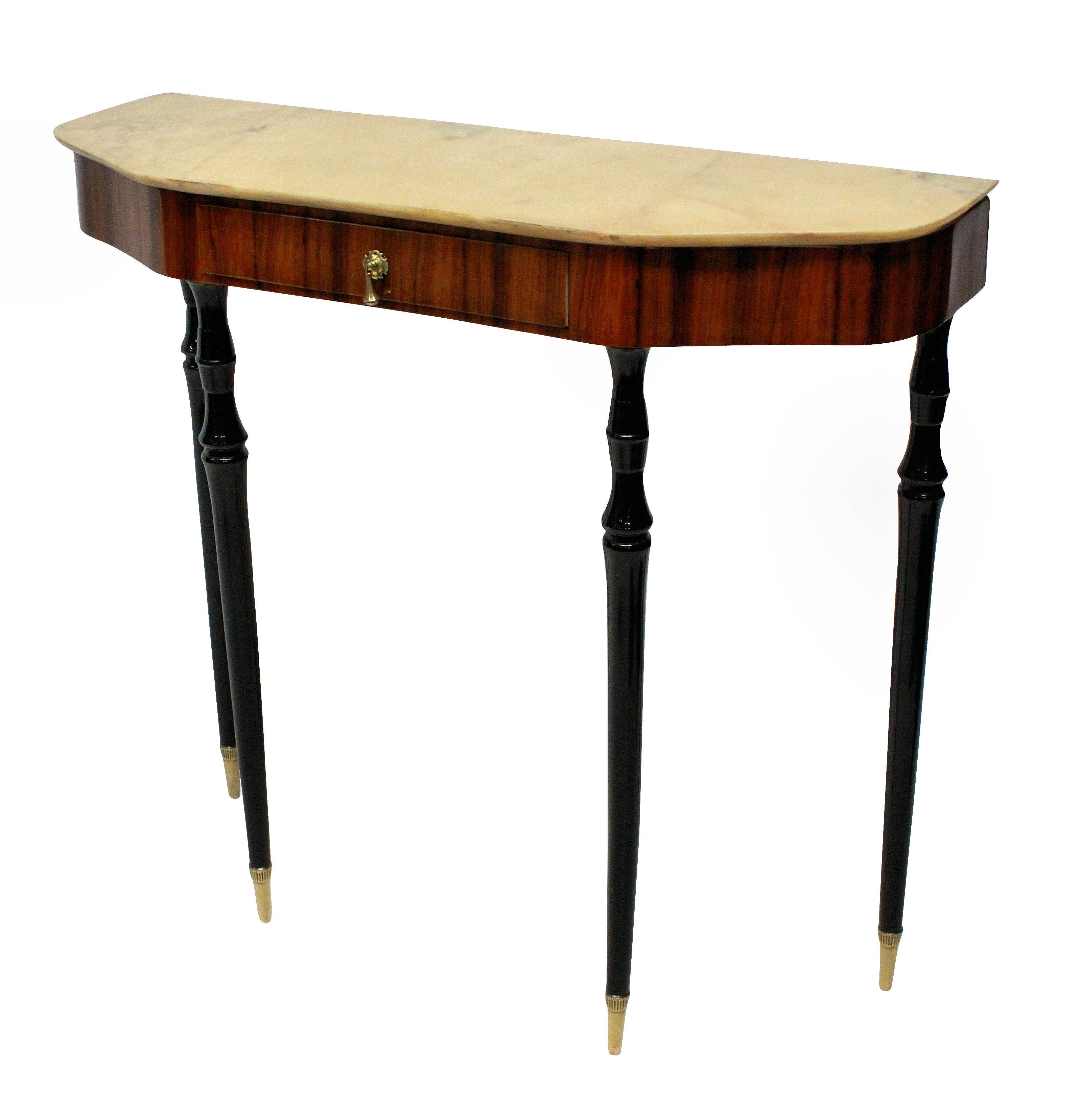 An elegant Italian midcentury console table, with ebonized tapering legs, a rosewood veneered frieze with drawer, brass hardware and a sienna marble top.