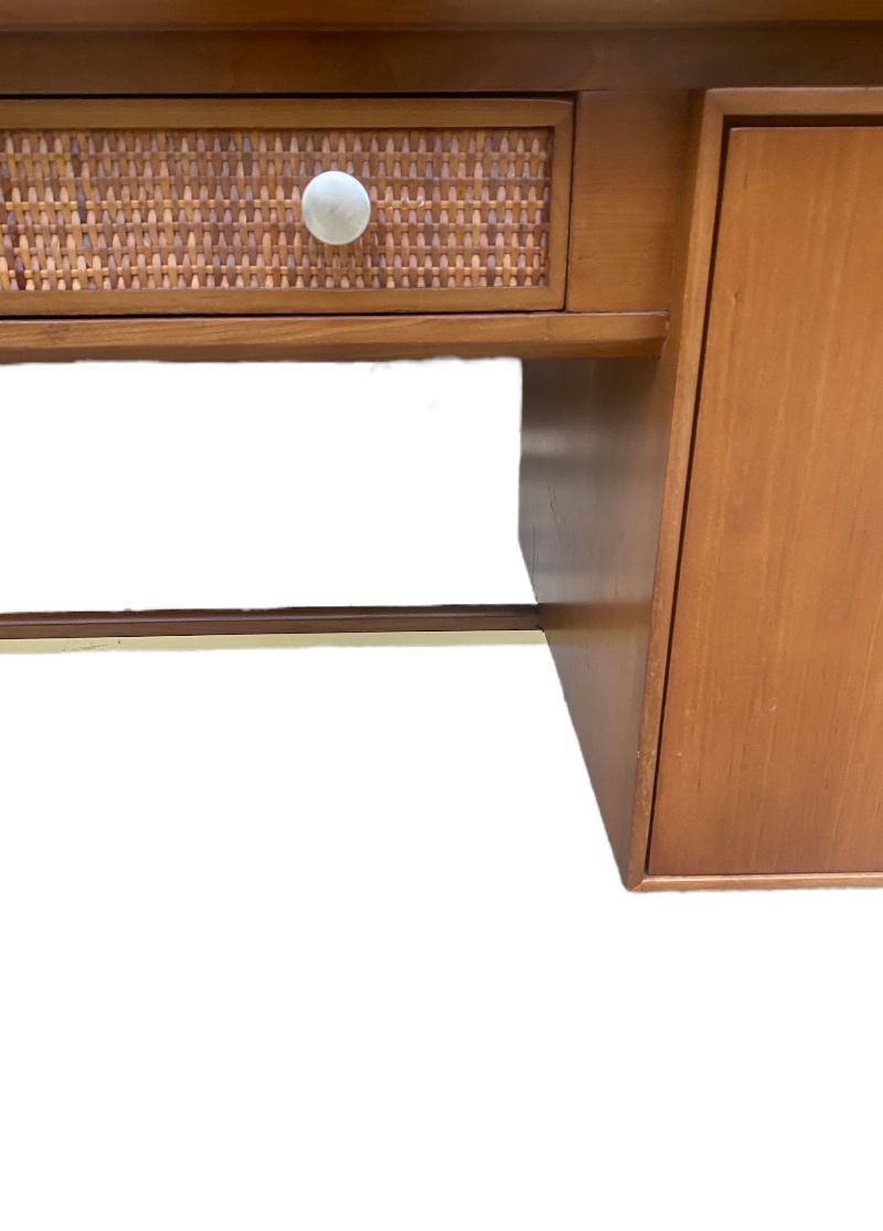 Elegant and tasteful midcentury modern desk. Designed by Kipp Stewart for the Sun Coast line by Drexel furniture. Executed in walnut with beautiful color and grain pattern. Original cane and brass detailing elevate this above its peers. Multiple