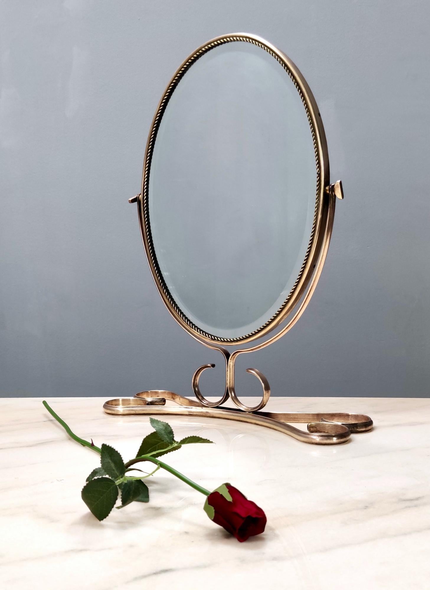 Italy, 1950s. 
It features a handmade brass frame, a wooden back and a beveled mirror.
This mirror is a vintage piece, therefore it might show slight traces of use, but it can be considered as in excellent original condition and ready to become a