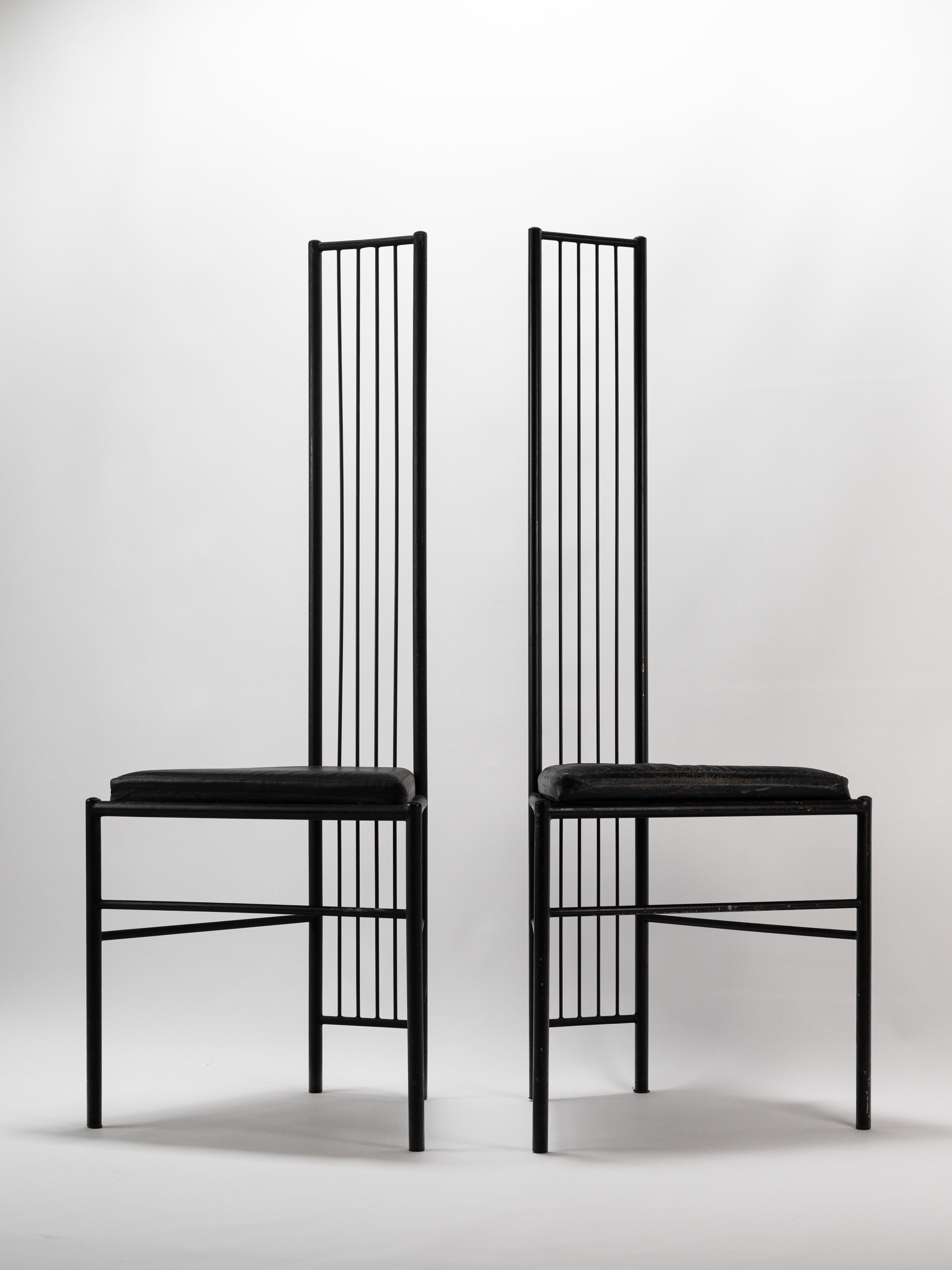 Cette paire de chaises étonnante, attribuée à Léopold Gest, incarne une esthétique audacieuse et sculpturale. Fabriquées en métal laqué noir, les chaises sont dotées de dossiers hauts et étroits formés par une série de tiges verticales élancées, ce