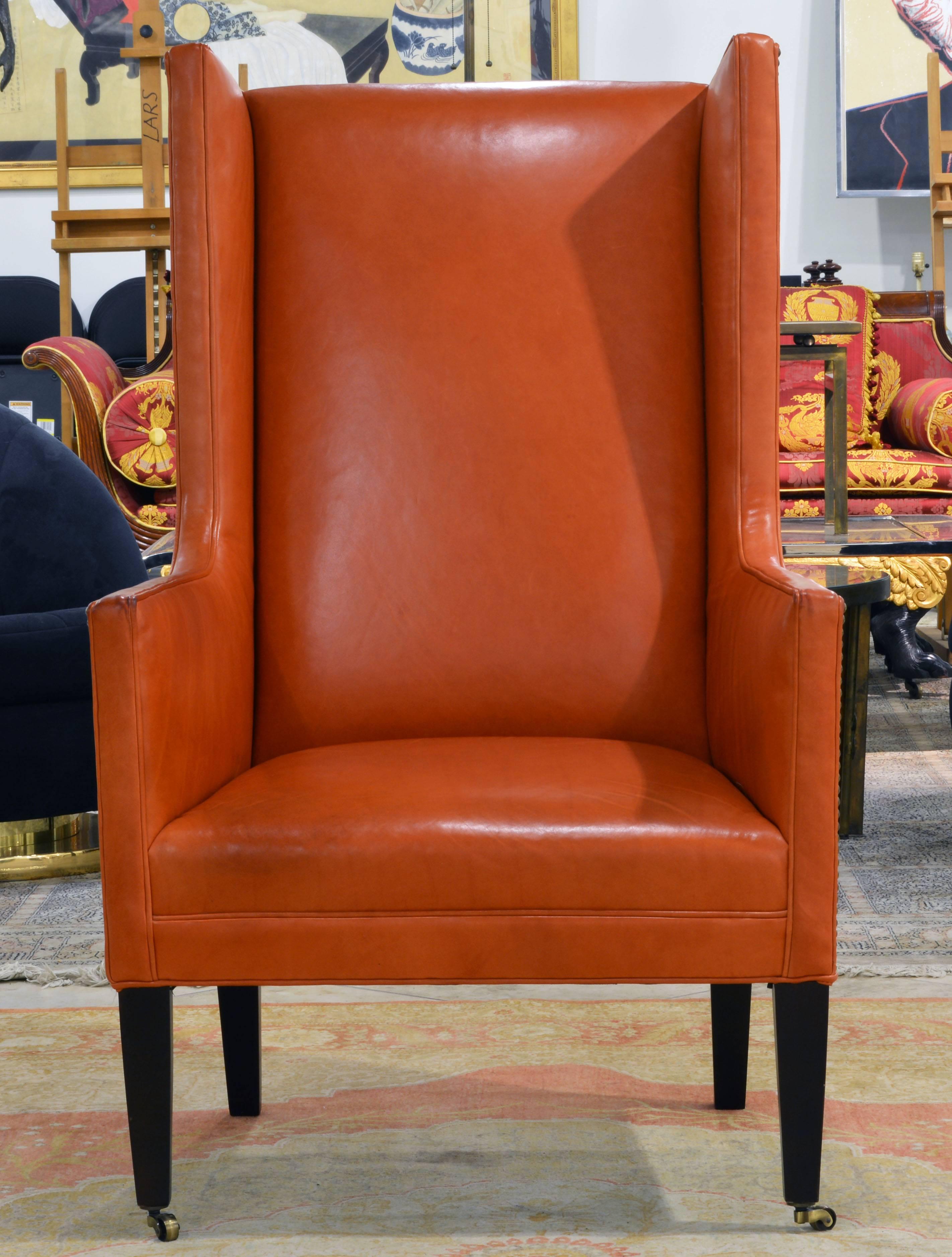 The Hermes orange color of the glove quality leather and the refined proportions and details make this chair stand out. The sides of the chair are accented by nail-head trim adding a Classic feel and the front legs rest on brass casters making